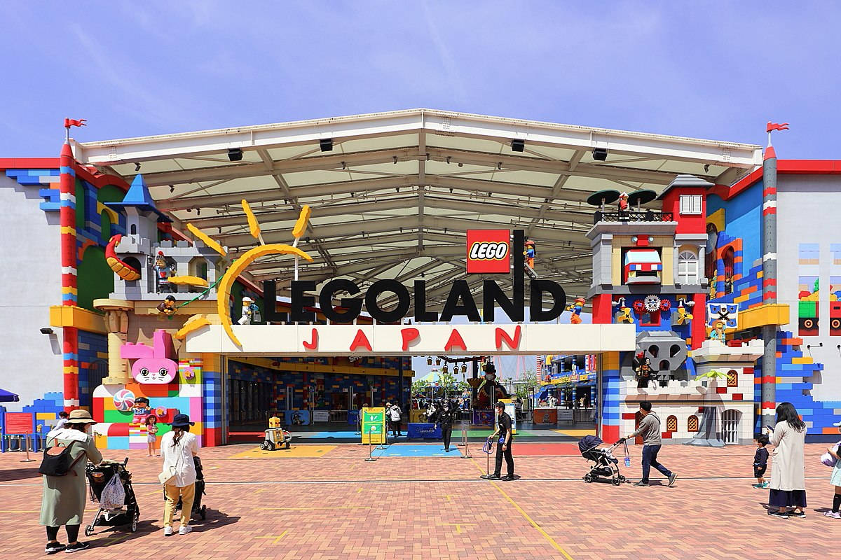 小孩動圖 桌布 壁紙 — 充滿活力的LEGO主題入口，通往LEGOLAND Japan，色彩繽紛的積木結構和遊客在晴朗的藍天下。
