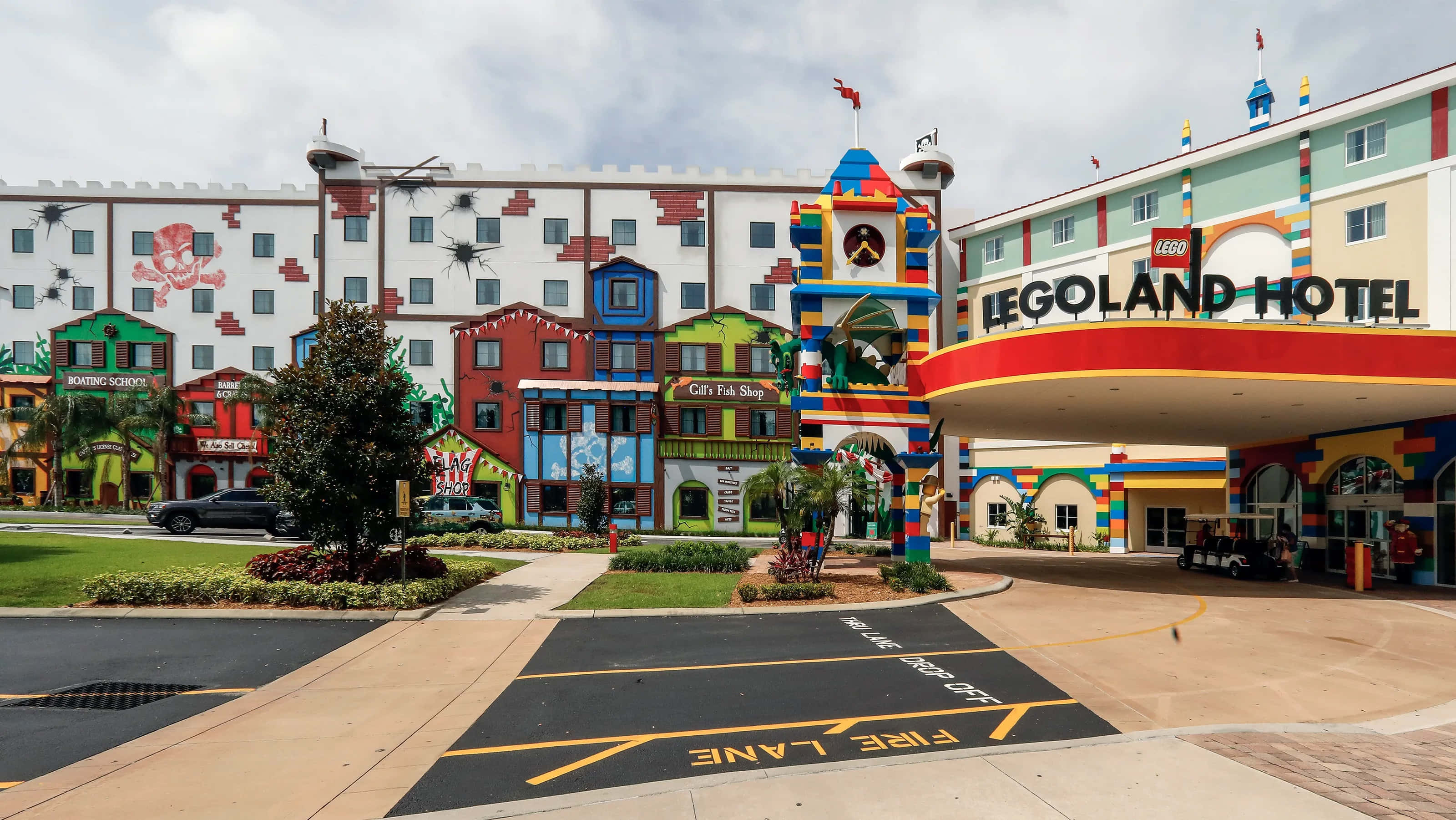Legoland 桌布 壁紙 — 充滿活力的LEGO主題飯店，擁有色彩繽紛的積木建築和有趣的標誌，在陰天天空下。