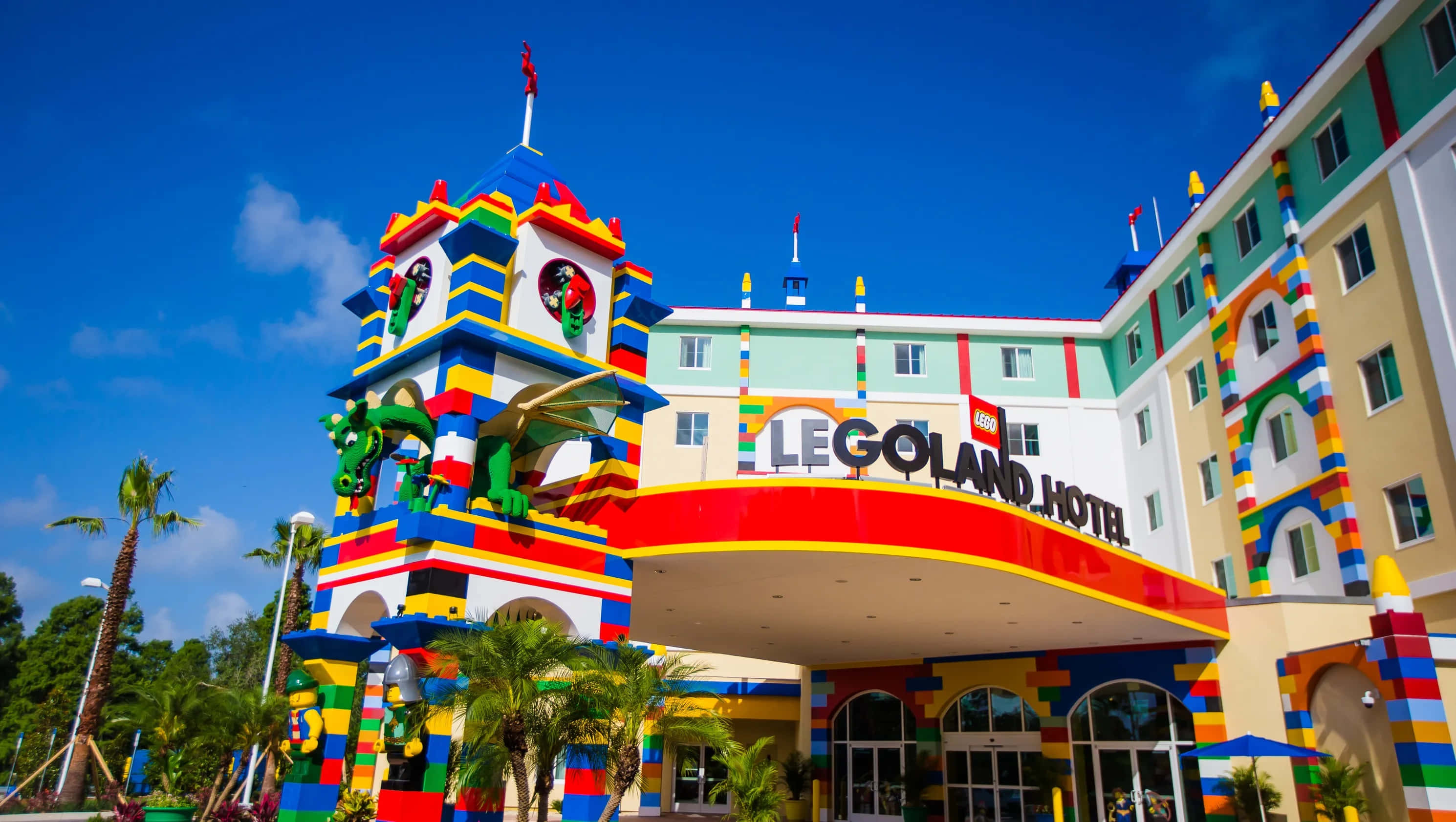 Legoland 桌布 壁紙 — 充滿活力的LEGO主題飯店，色彩繽紛的積木建築，藍天白雲和棕櫚樹。