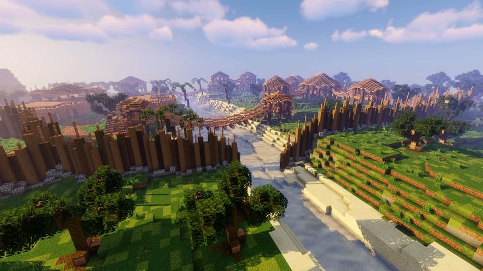 Minecraft Bridges 桌布 壁紙 — 充滿活力的Minecraft景觀，有像素化的樹木、草地、河流和遠處的村莊，在明亮的藍天下有蓬鬆的雲朵。