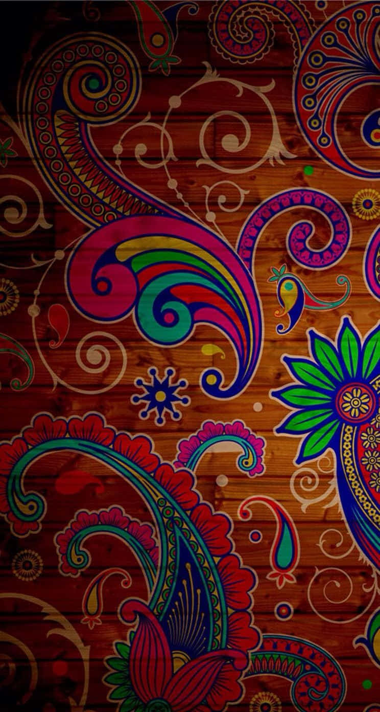 Paisley 桌布 壁紙 — 充滿活力的佩斯利和花卉圖案以彩虹色調點綴在質樸的木質背景上，帶有豐富的紅色和棕色。