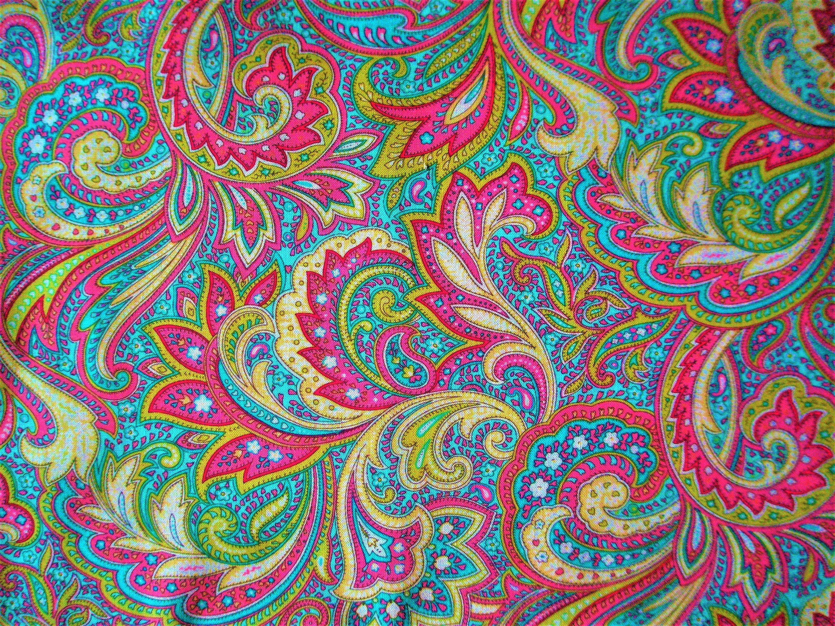 Paisley 桌布 壁紙 — 充滿活力的佩斯利圖案布料，帶有粉紅色、藍綠色、黃色和綠色的漩渦花卉圖案。
