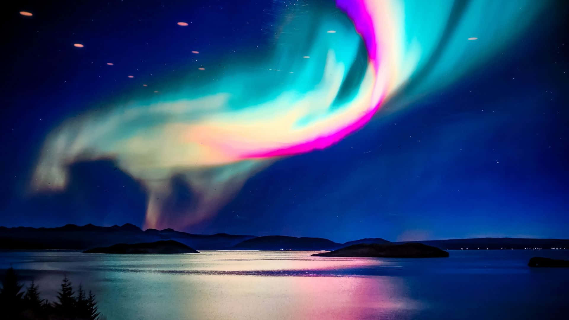 極光 桌布 壁紙 — 充滿活力的北極光在平靜的湖面上方的星空夜空中舞動，反射出其空靈的光芒。