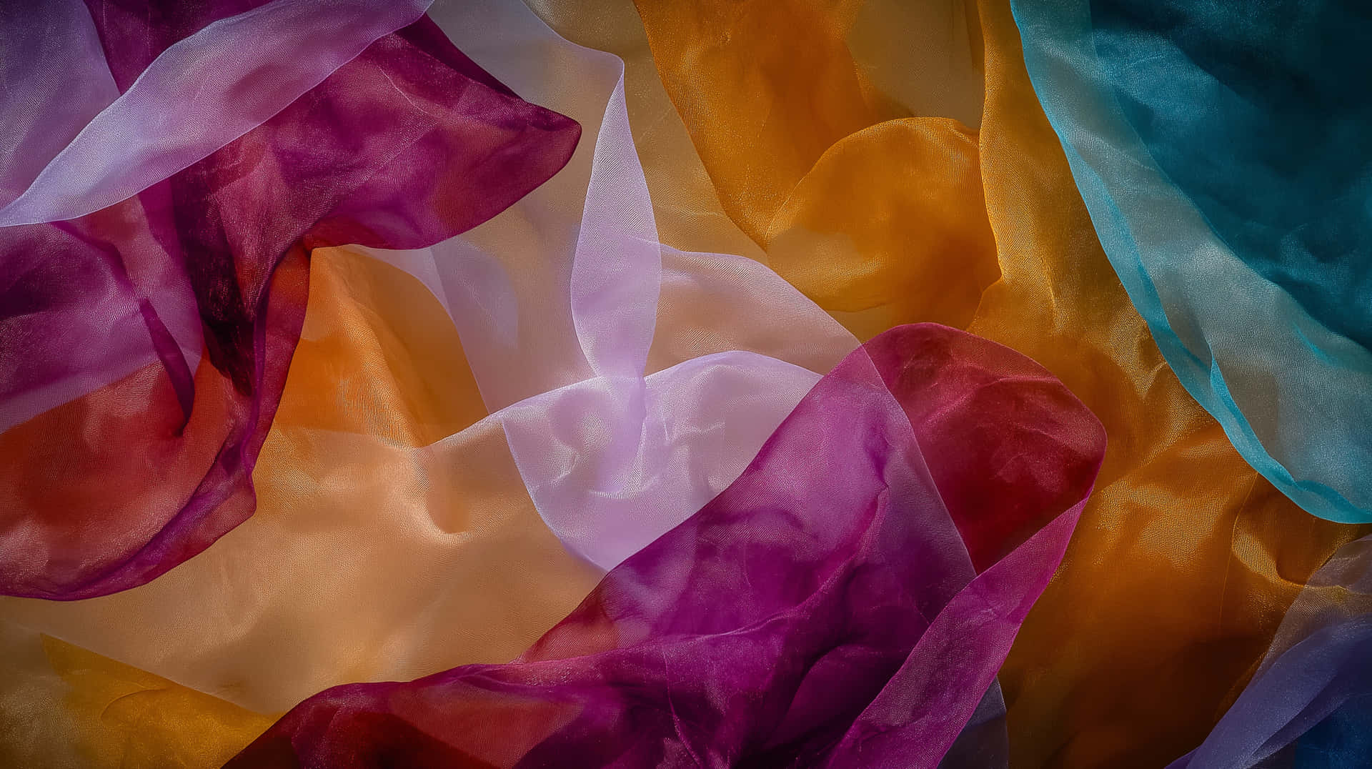 Artistic Translucent Fabric Swirls Multilayered Abstract 壁紙 — 充滿活力的半透明布料，以紫色、橙色和藍綠色呈現柔軟重疊的波浪，營造出夢幻般的抽象紋理。