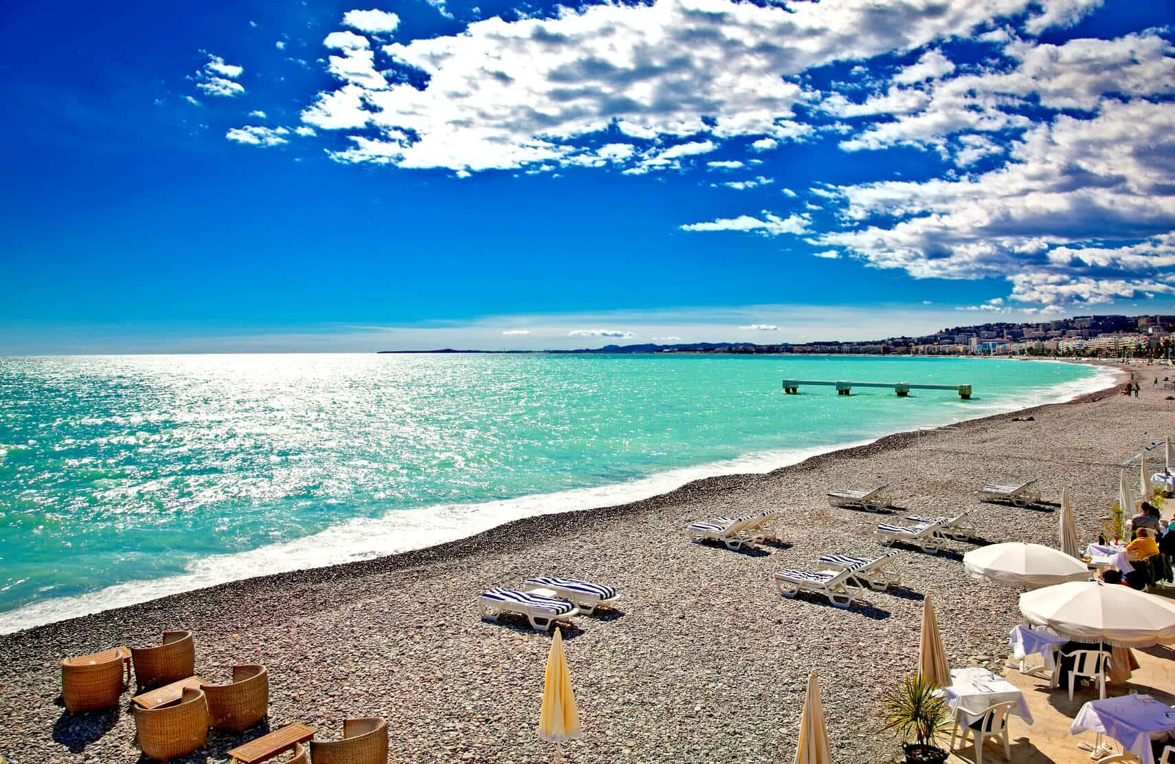 French Beach 桌布 壁紙 — 充滿活力的卵石海灘，碧綠的海水，白色的躺椅，藍天白雲。