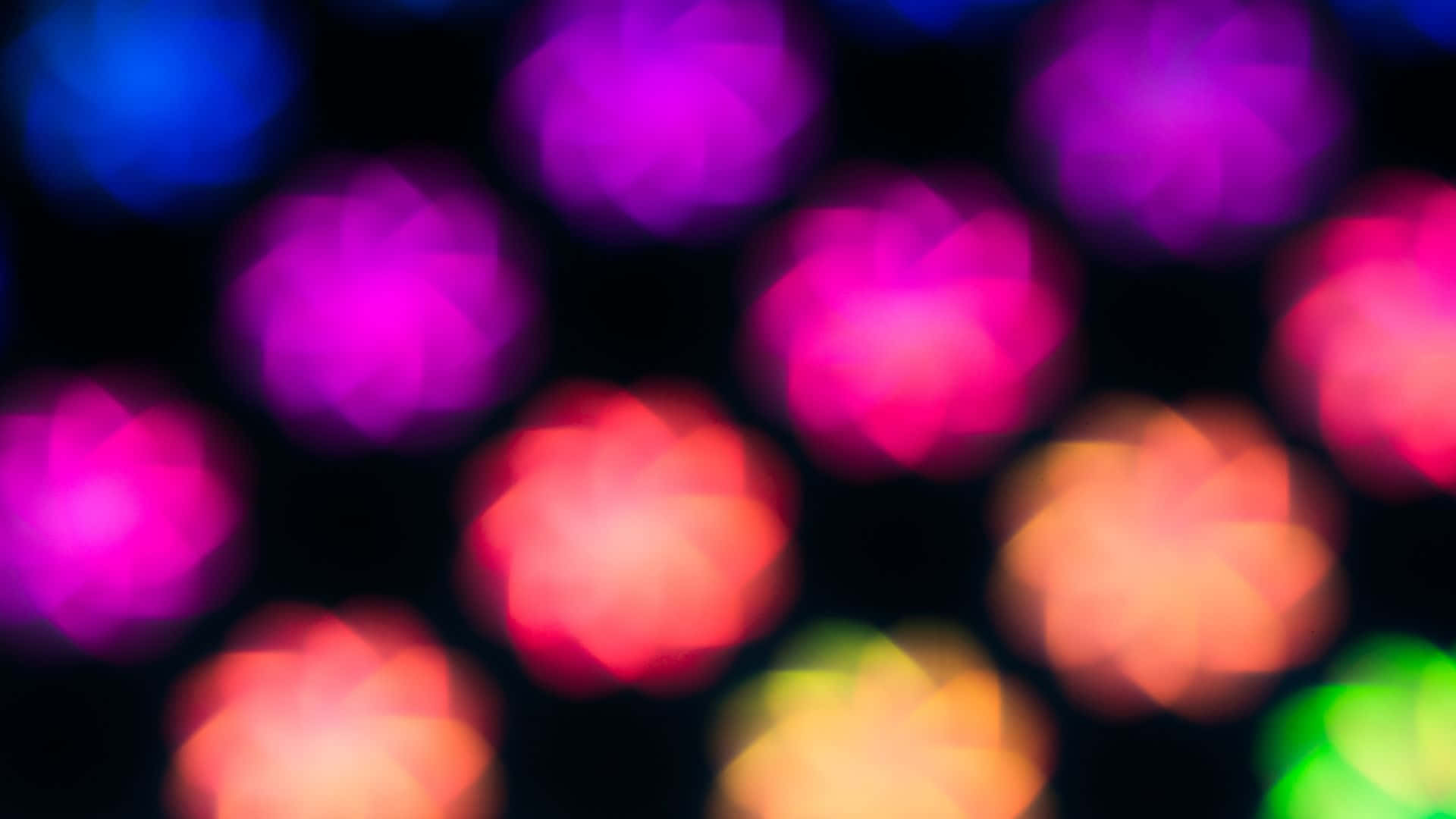 Glow In The Dark 桌布 壁紙 — 充滿活力的圓形散景燈光，紫色、粉紅色、橙色和藍色在深色背景上柔和發光。