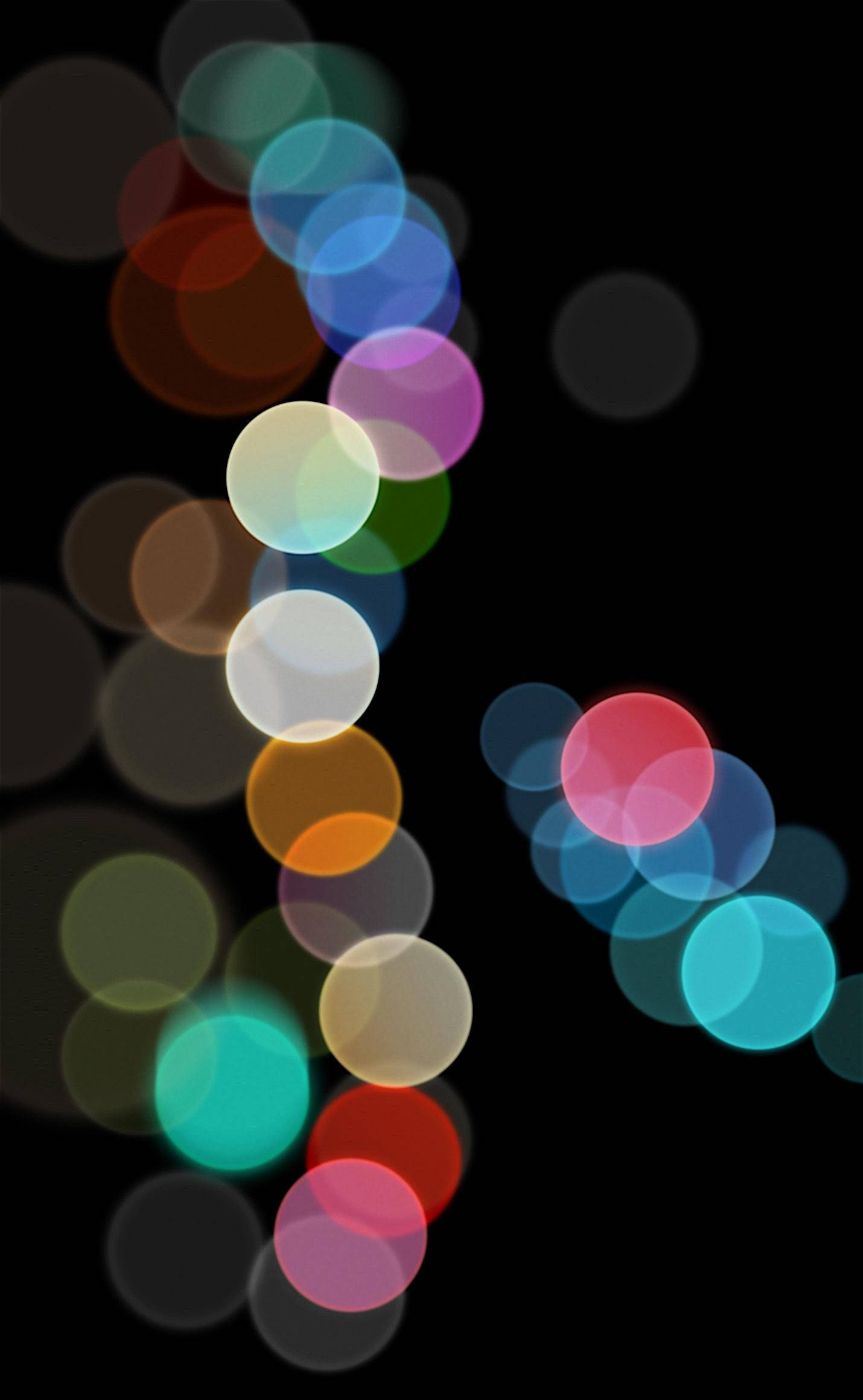 iPhone 桌布 壁紙 — 充滿活力的圓形散景燈光在深黑色背景上對角線流瀉，營造出夢幻般的抽象光芒。