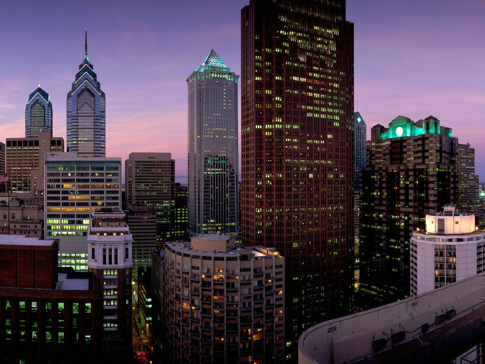 Philadelphia 桌布 壁紙 — 充滿活力的城市天際線，在黃昏時分，高聳的摩天大樓在紫色和粉紅色的暮色天空中閃耀。