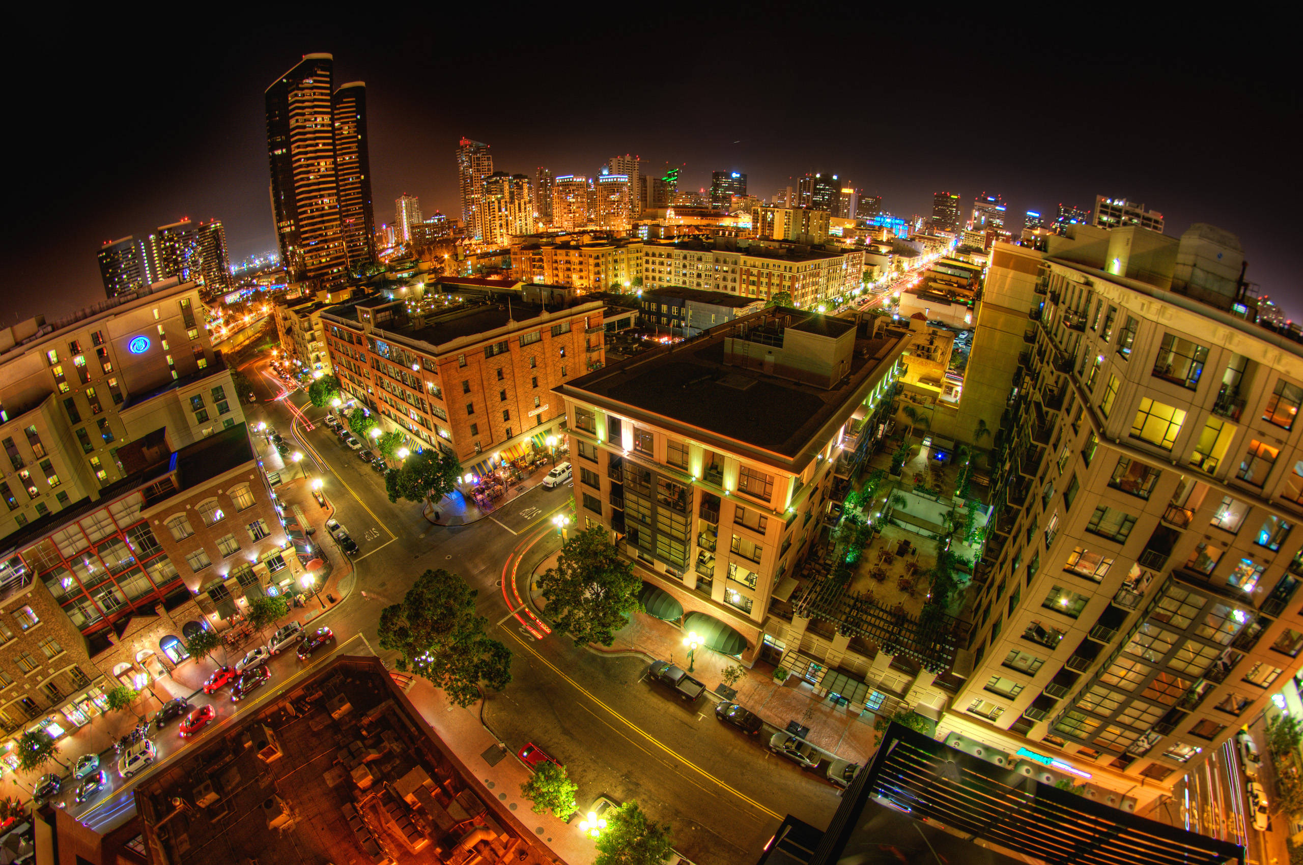 View 桌布 壁紙 — 充滿活力的城市景觀的夜間空中視圖，發光的建築物和劃過的街燈照亮蜿蜒的道路。