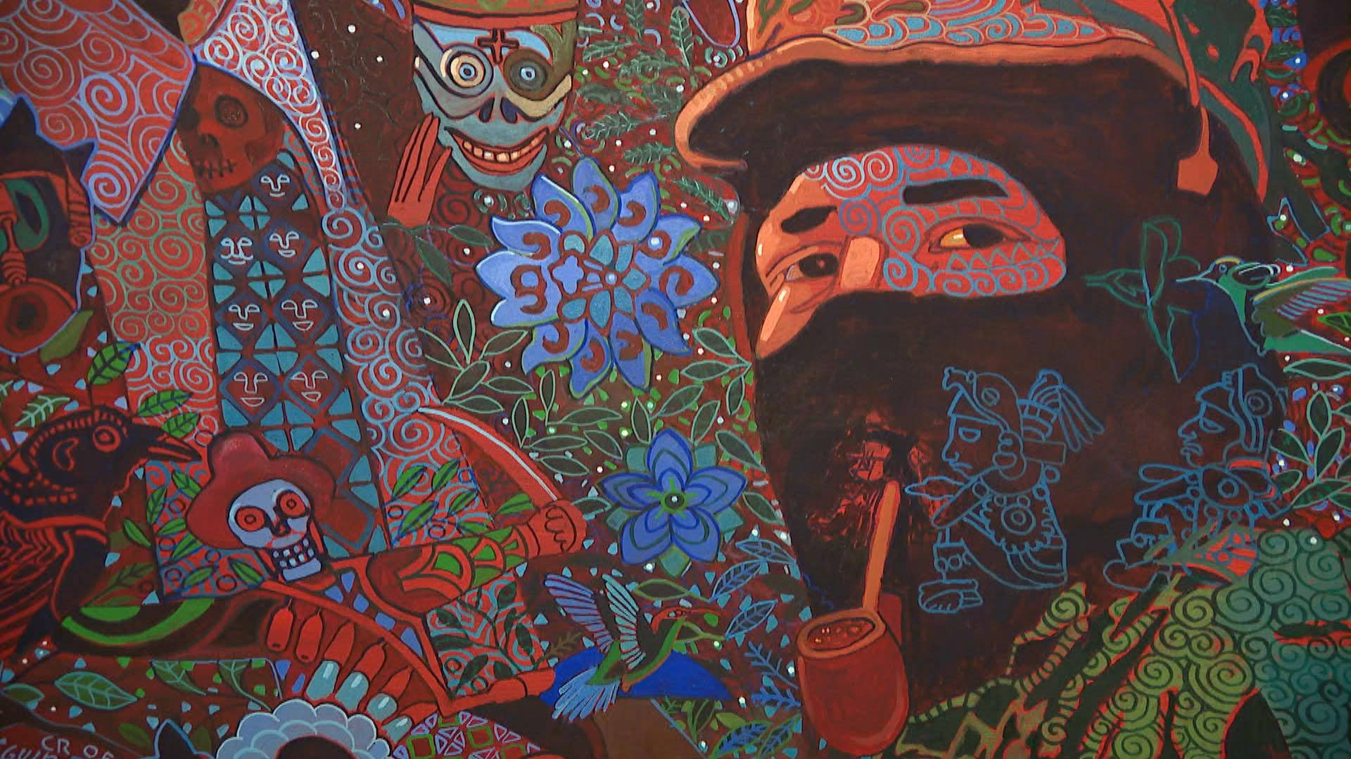 Folk Art 桌布 壁紙 — 充滿活力的壁畫藝術描繪了一個留鬍鬚的人物，帶有華麗的圖案、頭骨、花朵和鳥類，色彩豐富的紅色、藍色和綠色。