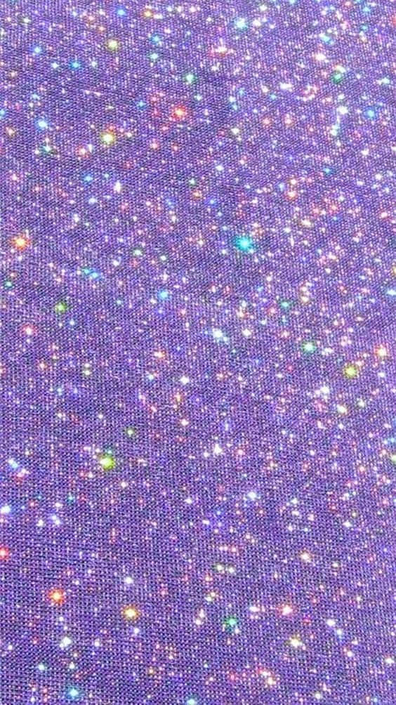 Light Purple Glitter 桌布 壁紙 — 充滿活力的多色亮粉顆粒在帶紋理的紫色布料表面上閃爍的特寫。