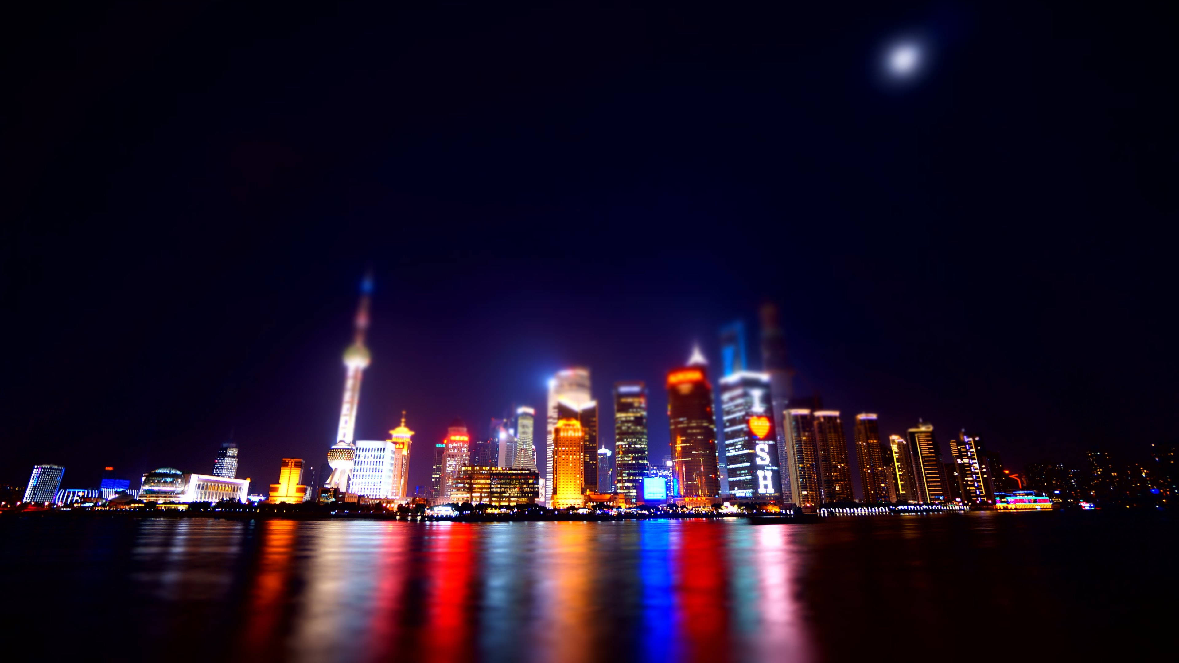 Shanghai 桌布 壁紙 — 充滿活力的夜景，月光下發光的摩天大樓倒映在水中。
