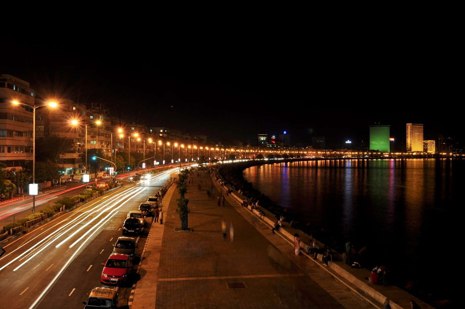 Mumbai 桌布 壁紙 — 充滿活力的夜景，海濱長廊上閃爍的路燈和汽車軌跡反射著霓虹燈光。