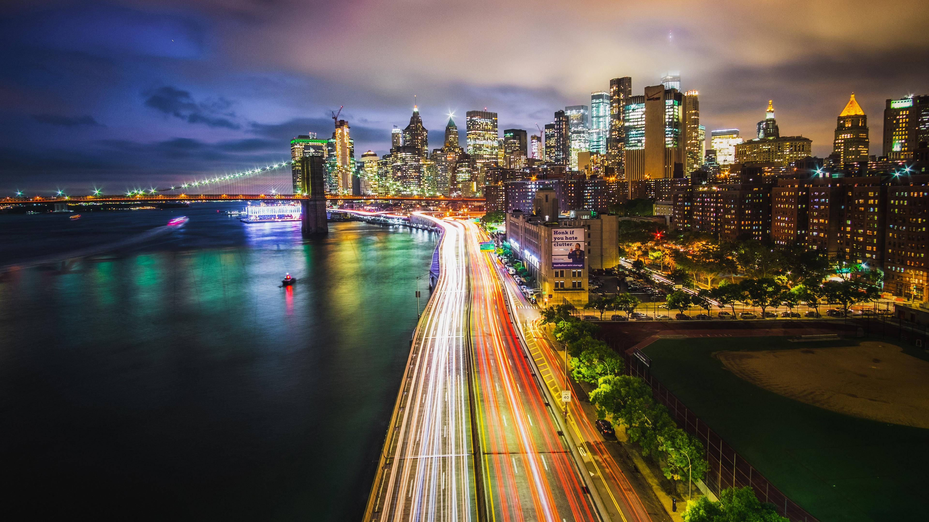 Skyscraper 桌布 壁紙 — 充滿活力的夜景，海濱高速公路上的車流形成光軌，映襯著閃爍的天際線。