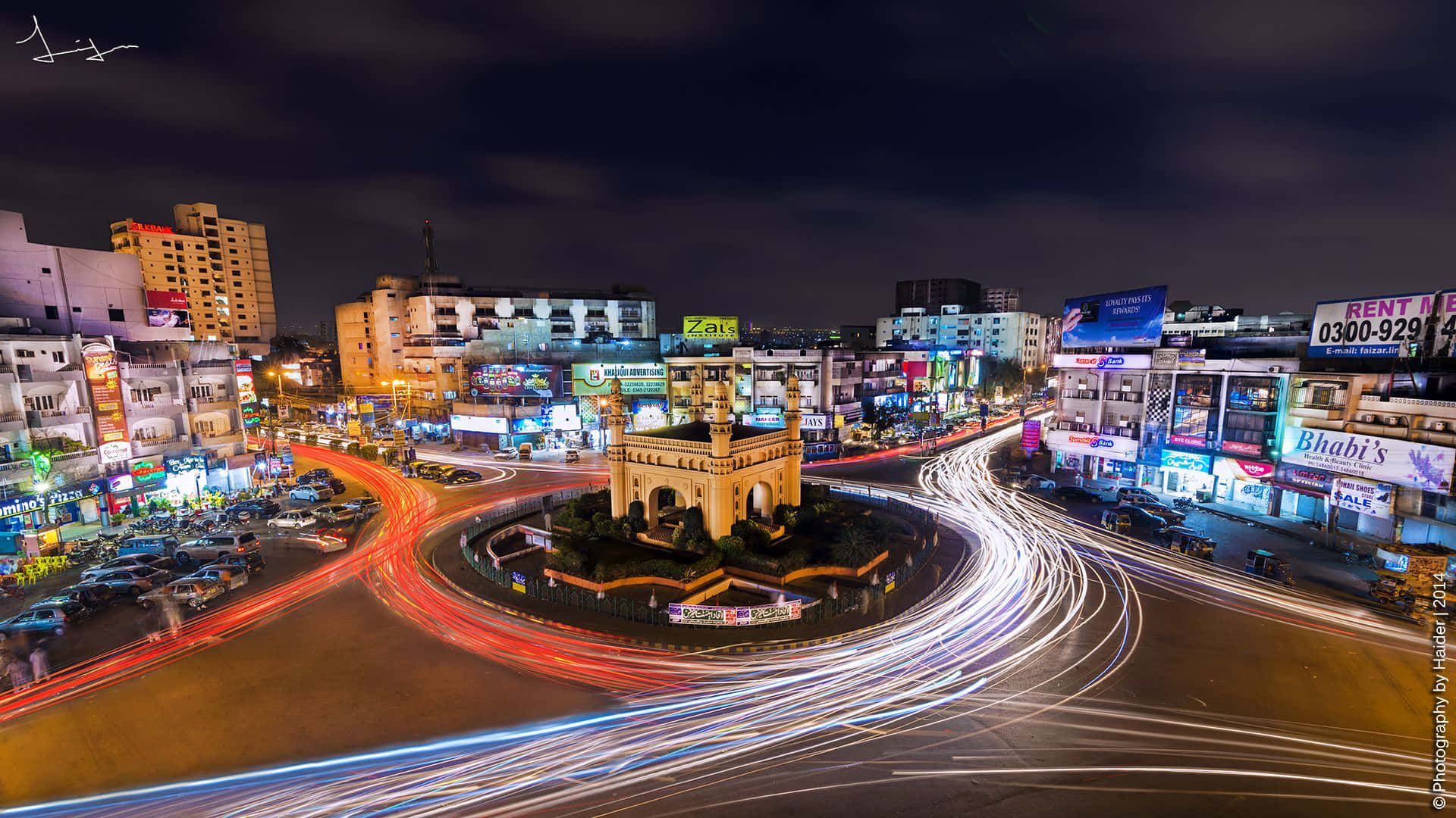 Pakistan 桌布 壁紙 — 充滿活力的夜景，車流燈光圍繞中央歷史紀念碑旋轉。