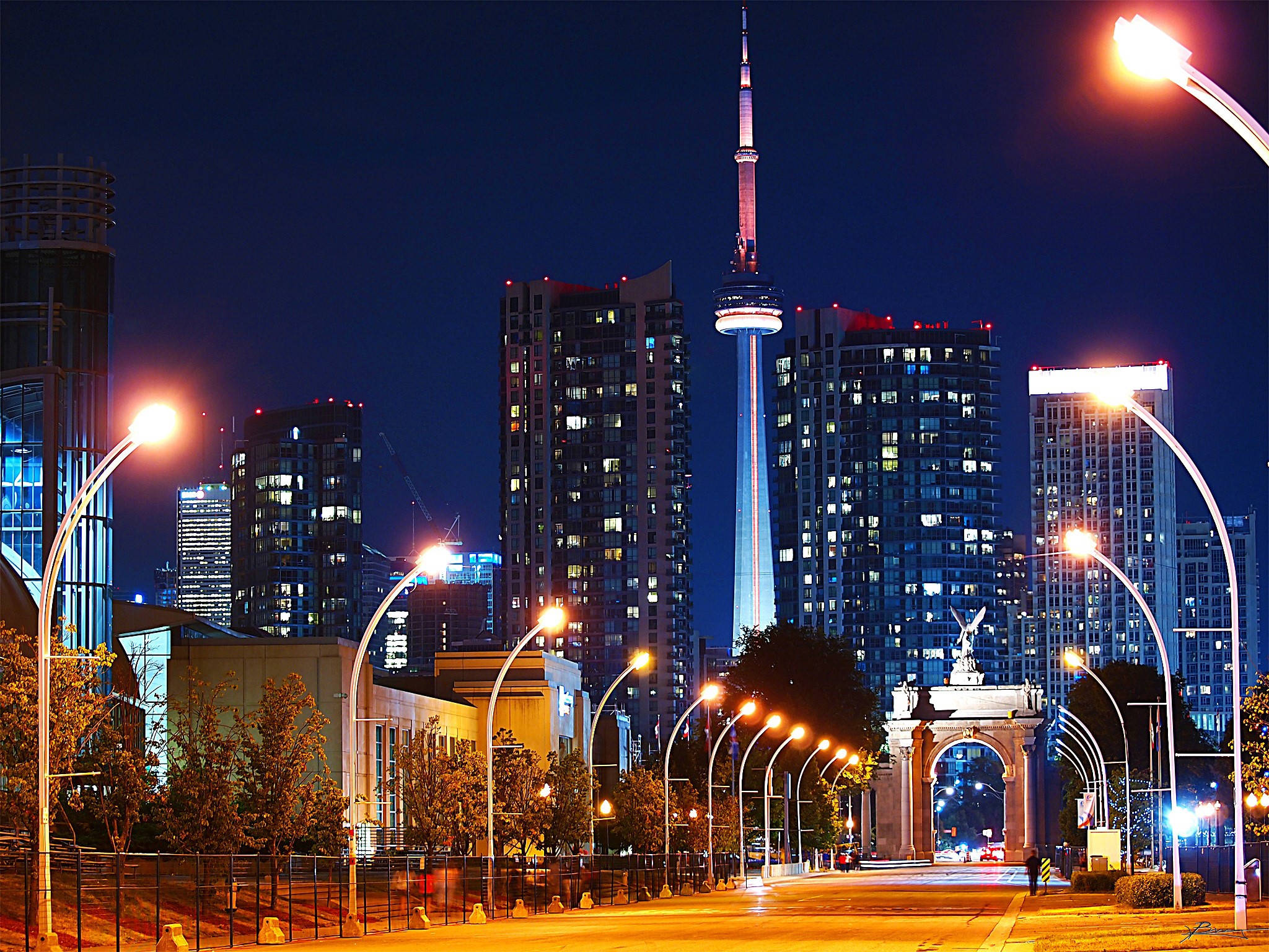 Ontario 桌布 壁紙 — 充滿活力的夜景城市景觀，以深藍色天空為背景，點亮的CN塔和發光的街燈。