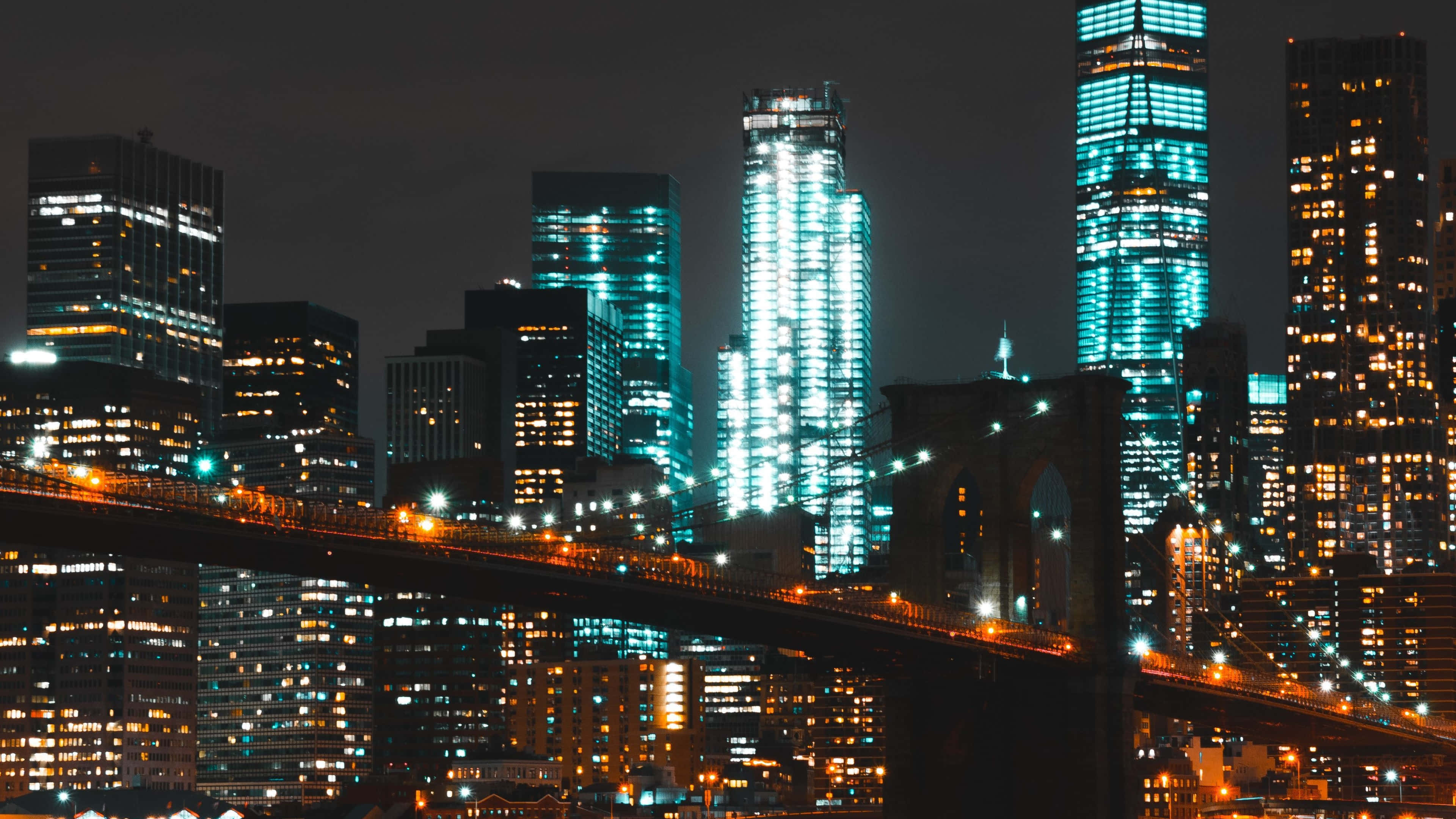 Skyscraper 桌布 壁紙 — 充滿活力的夜景城市景觀，以黑暗天空為背景，閃爍的摩天大樓和亮燈的橋樑。