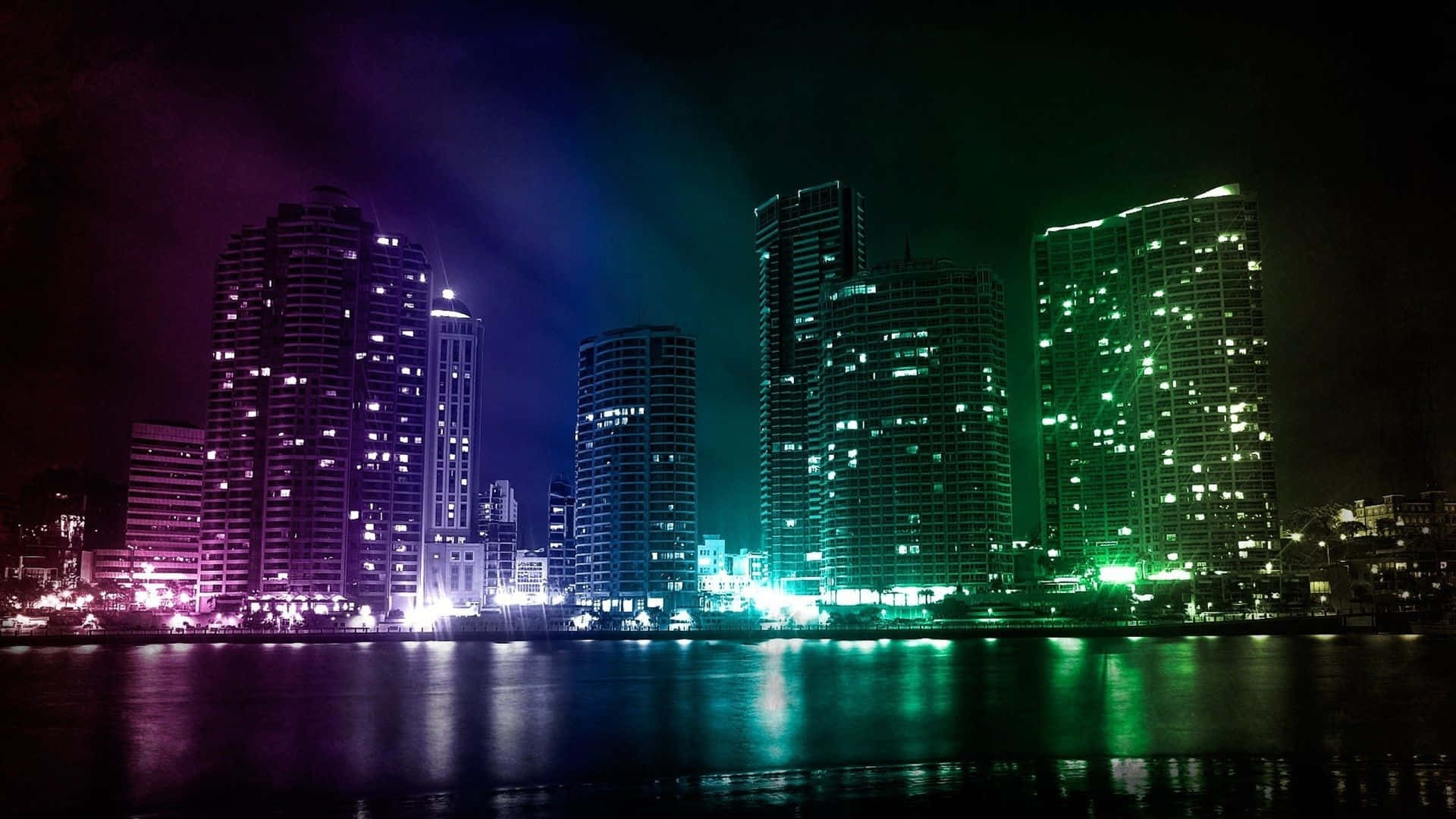 Neon Green And Purple 桌布 壁紙 — 充滿活力的夜景城市景觀，摩天大樓在平靜的水面上反射出紫色和綠色的光芒。