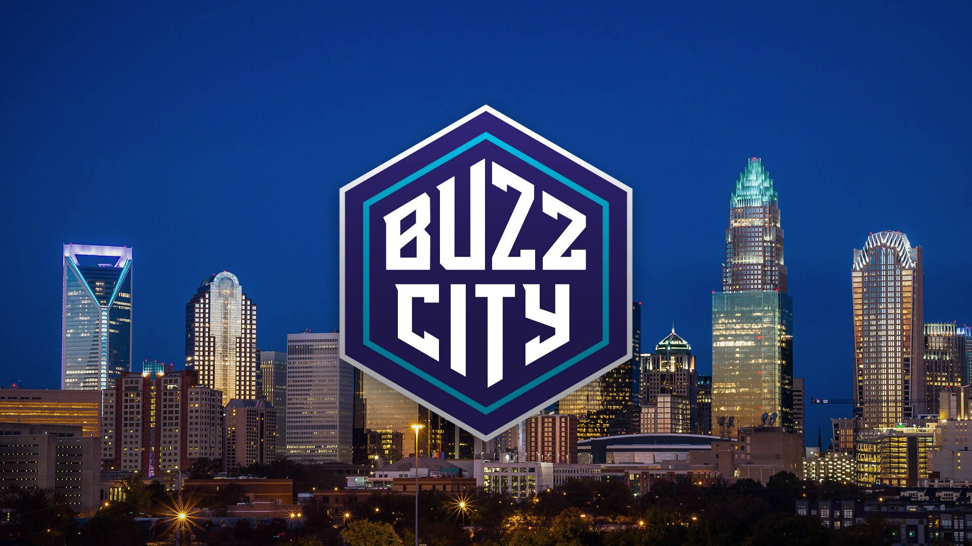 Hornets 桌布 壁紙 — 充滿活力的夜景城市景觀，有燈火通明的摩天大樓和突出的六邊形「Buzz City」標誌疊加。