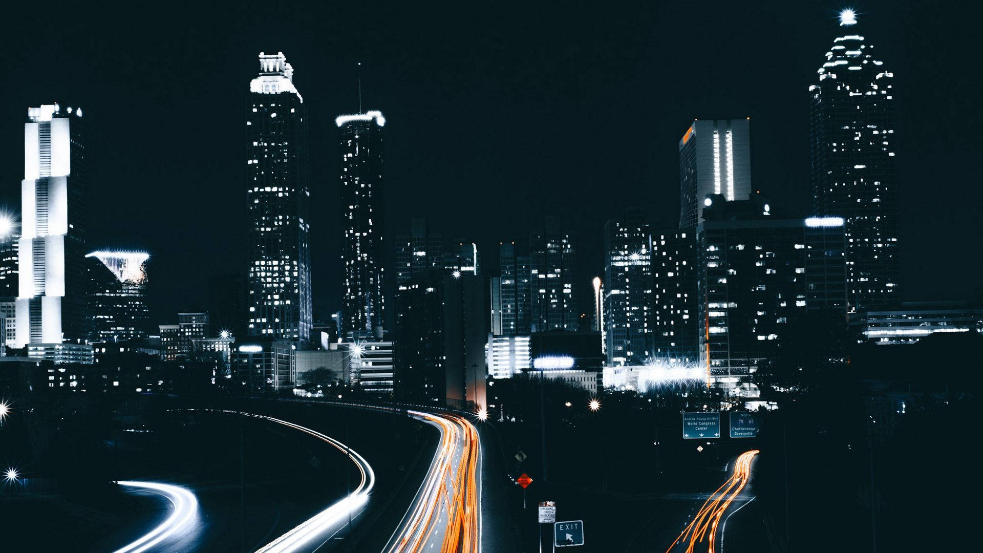 Atlanta 桌布 壁紙 — 充滿活力的夜景城市景觀，閃爍的摩天大樓和蜿蜒高速公路上的車流光跡。