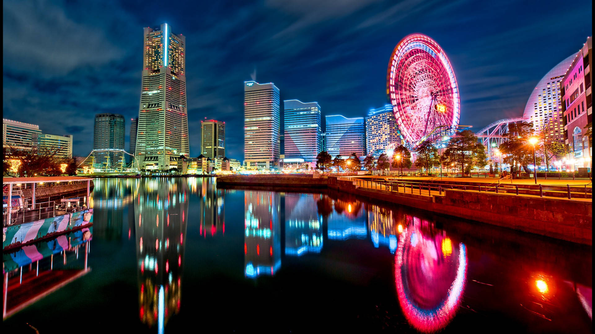 lights 桌布 壁紙 — 充滿活力的夜景城市景觀，閃爍的摩天大樓和色彩繽紛的摩天輪倒映在平靜的水面上。