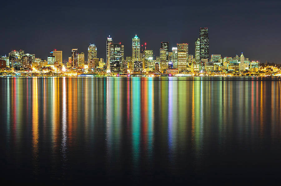 Seattle Skyline 桌布 壁紙 — 充滿活力的夜間城市天際線，閃爍的摩天大樓完美倒映在平靜的暗色水面上。