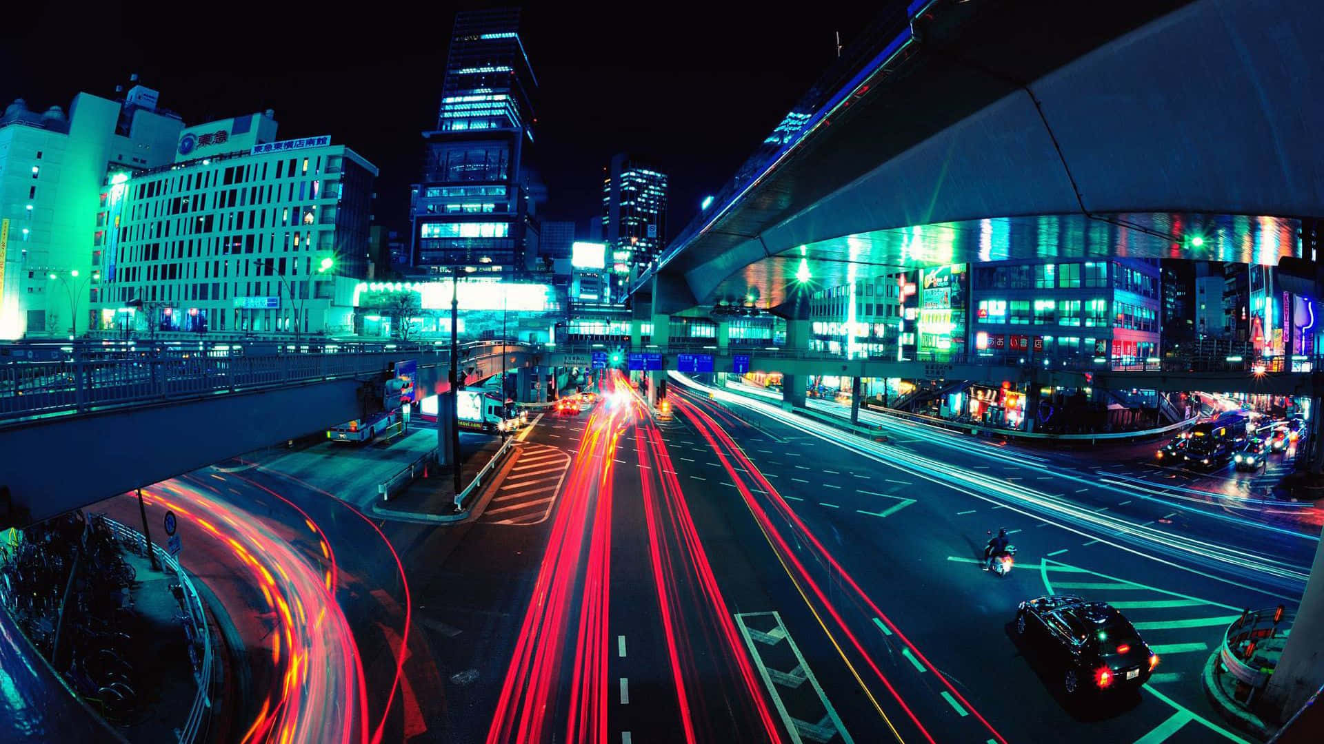 Cyberpunk Aesthetic 桌布 壁紙 — 充滿活力的夜間城市景觀，在發光的霓虹燈招牌和高聳的摩天大樓下，交通留下紅色和白色的光跡。