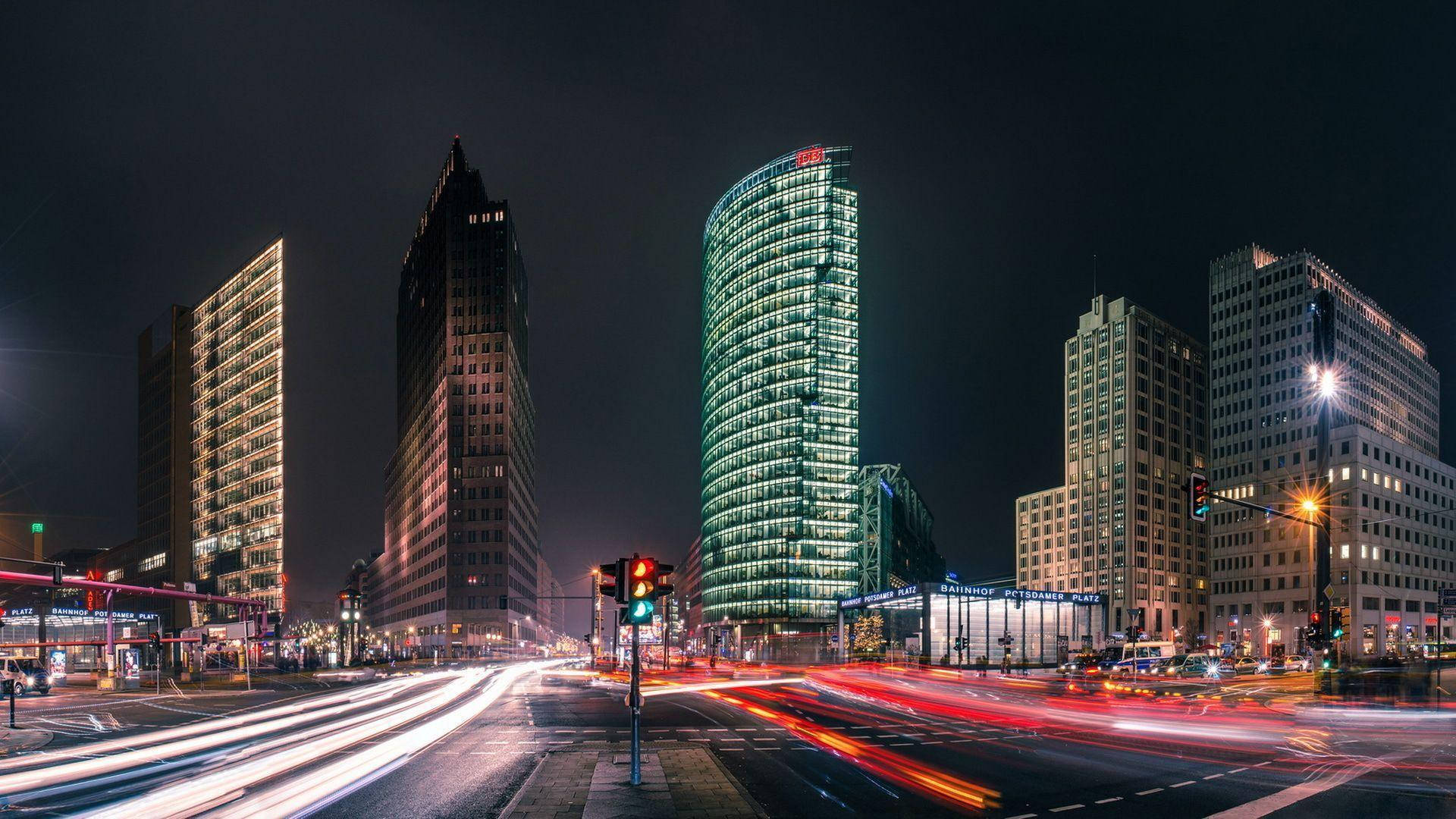 Berlin 桌布 壁紙 — 充滿活力的夜間城市景觀，閃爍的摩天大樓和車流的光軌。