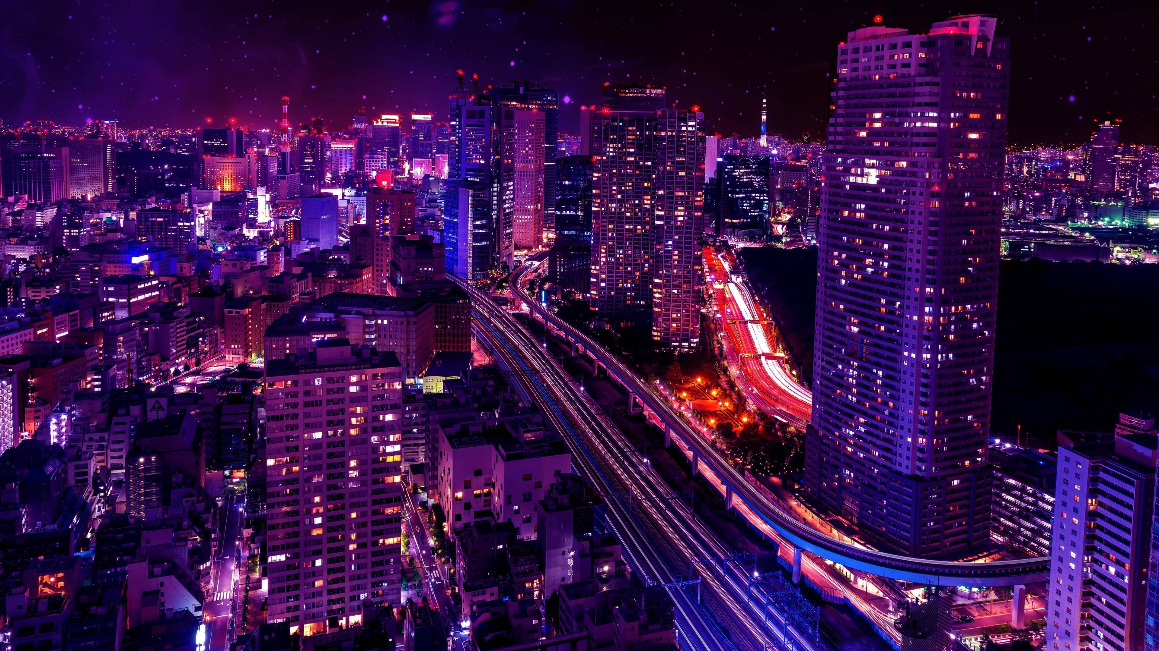 日本 桌布 壁紙 — 充滿活力的夜間城市景觀，閃爍的摩天大樓和高架高速公路上的車流光跡。