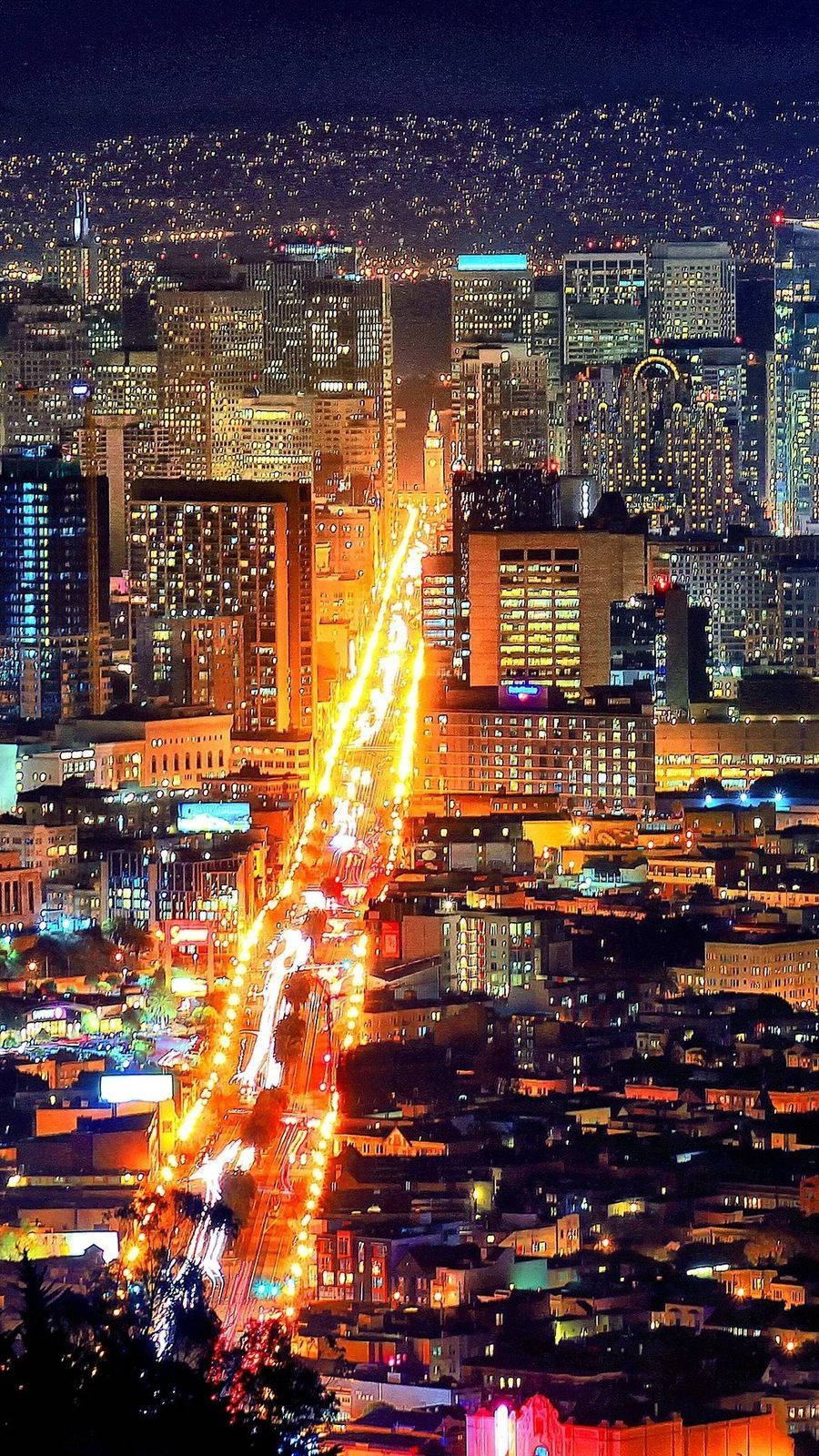 san francisco iPhone 桌布 壁紙 — 充滿活力的夜間城市景觀，閃爍的摩天大樓和流動的車燈照亮蜿蜒的城市峽谷。