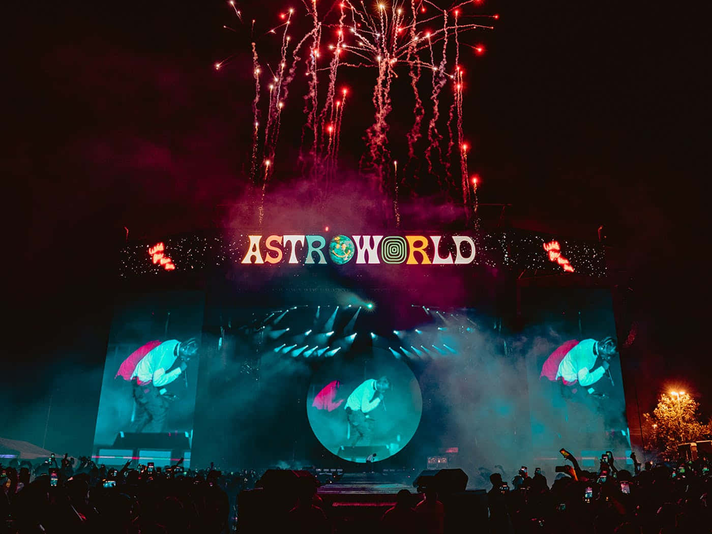 Astroworld 桌布 壁紙 — 充滿活力的夜間音樂會，煙火在巨大的「ASTROWORLD」舞台上空爆炸，舞台被五彩燈光和煙霧照亮。