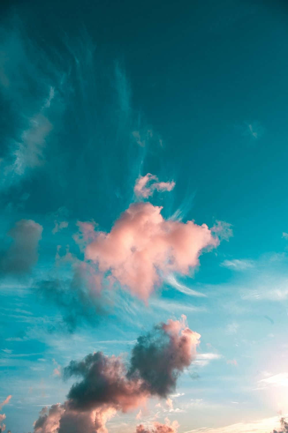 雲朵 桌布 壁紙 — 充滿活力的天空，帶有藍綠色調和柔和的粉紅色雲朵，被日落光照亮。