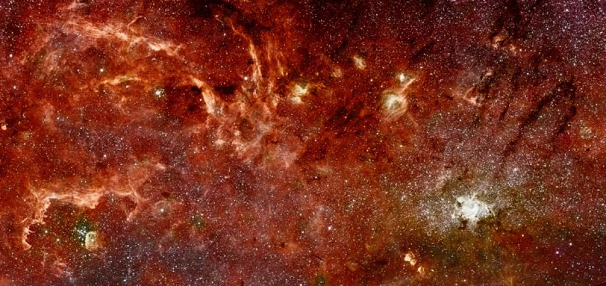 Galactic Center 桌布 壁紙 — 充滿活力的宇宙星雲，帶有發光的橙色絲狀物和散落的星星，背景是深紅色的宇宙。