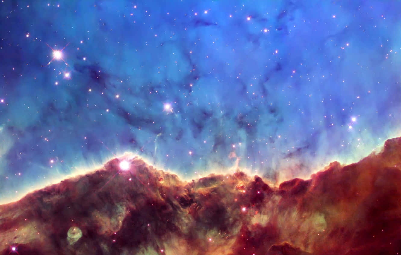 銀河 桌布 壁紙 — 充滿活力的宇宙星雲，帶有發光的紅橙色雲朵和明亮的星星，背景是深藍色的星空。