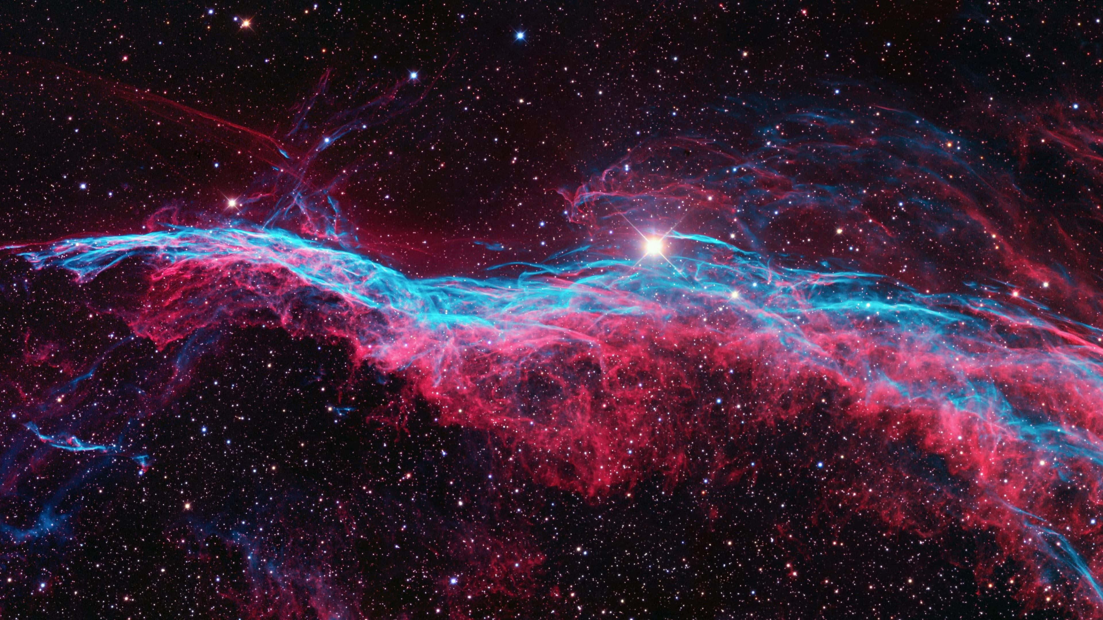桌布 壁紙 — 充滿活力的宇宙星雲，旋轉的紅色和藍色氣體被明亮的星星照亮，背景是黑暗的星空。