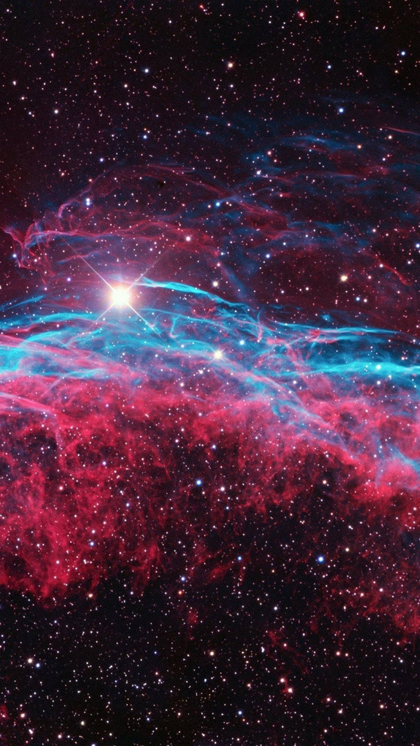 銀河 桌布 壁紙 — 充滿活力的宇宙星雲，有旋轉的紅色和藍色雲層，由明亮的中心恆星照亮，背景是星場。