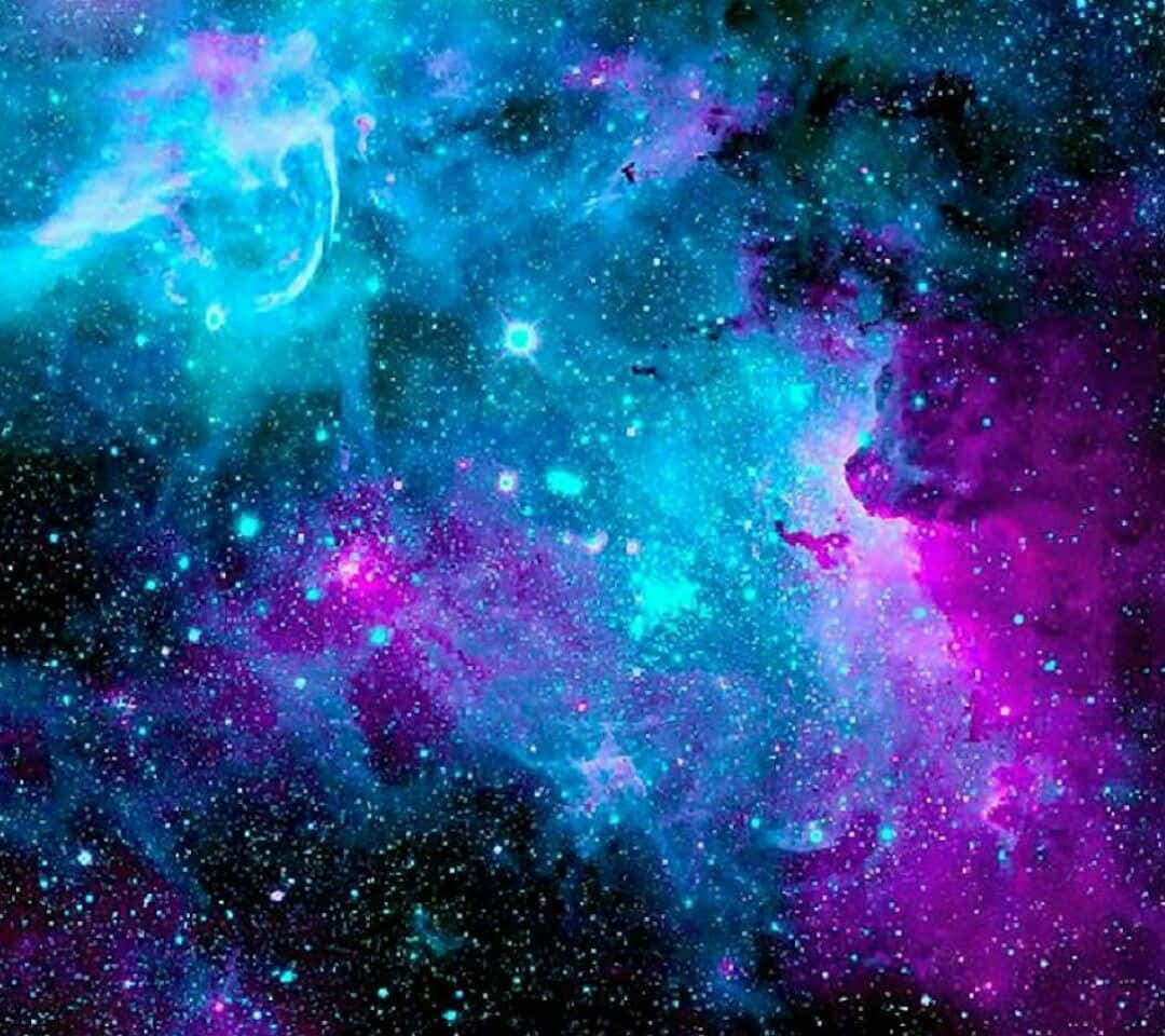 Cool Blue Galaxy 桌布 壁紙 — 充滿活力的宇宙星雲在佈滿星星的虛空中以電光藍和洋紅色旋轉。