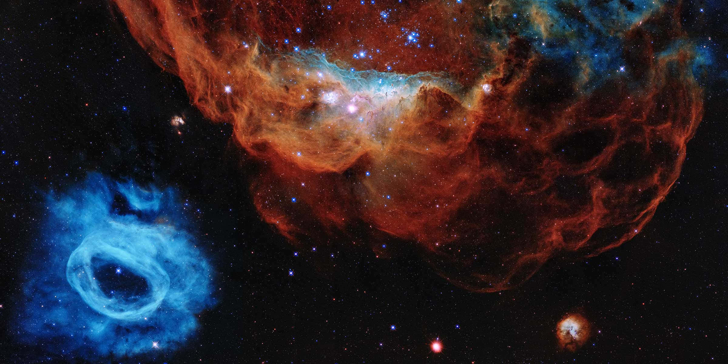 太空 桌布 壁紙 — 充滿活力的宇宙星雲在佈滿星辰的黑色虛空中散發出火紅和冷藍的光芒。