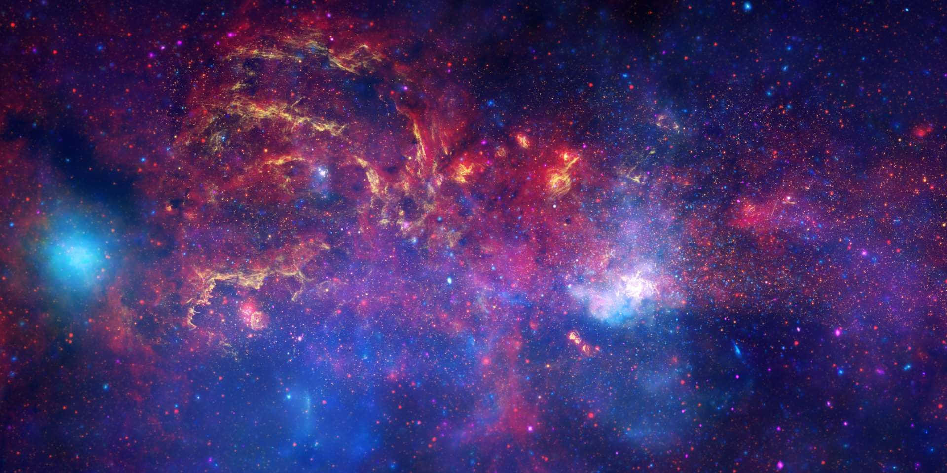 Galactic Center 桌布 壁紙 — 充滿活力的宇宙星雲在星空背景下以火紅、金色和深藍色旋轉。