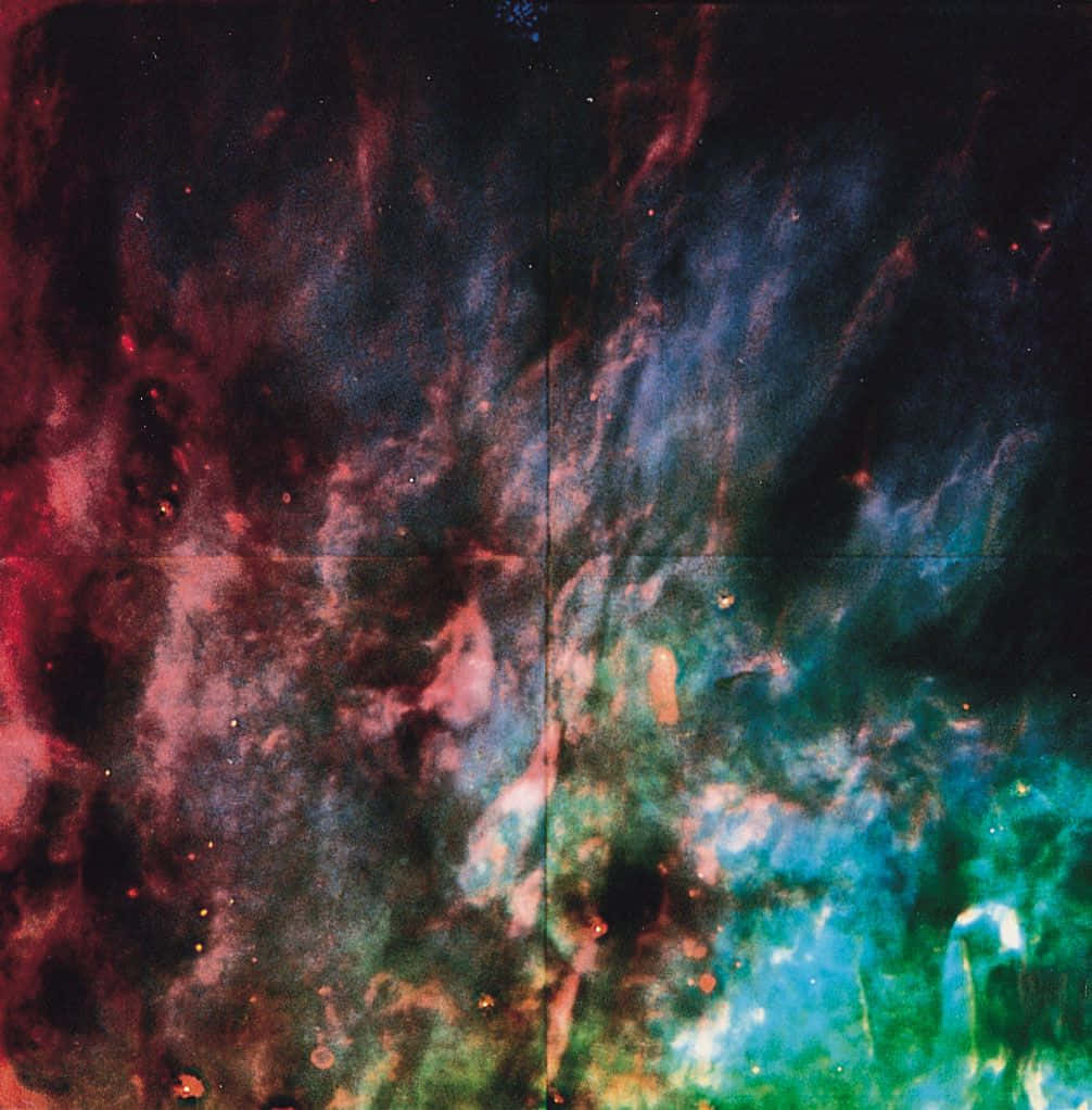 星雲 桌布 壁紙 — 充滿活力的宇宙星雲在深邃的紅色、藍色和綠色中旋轉，背景是繁星點點的黑色虛空。