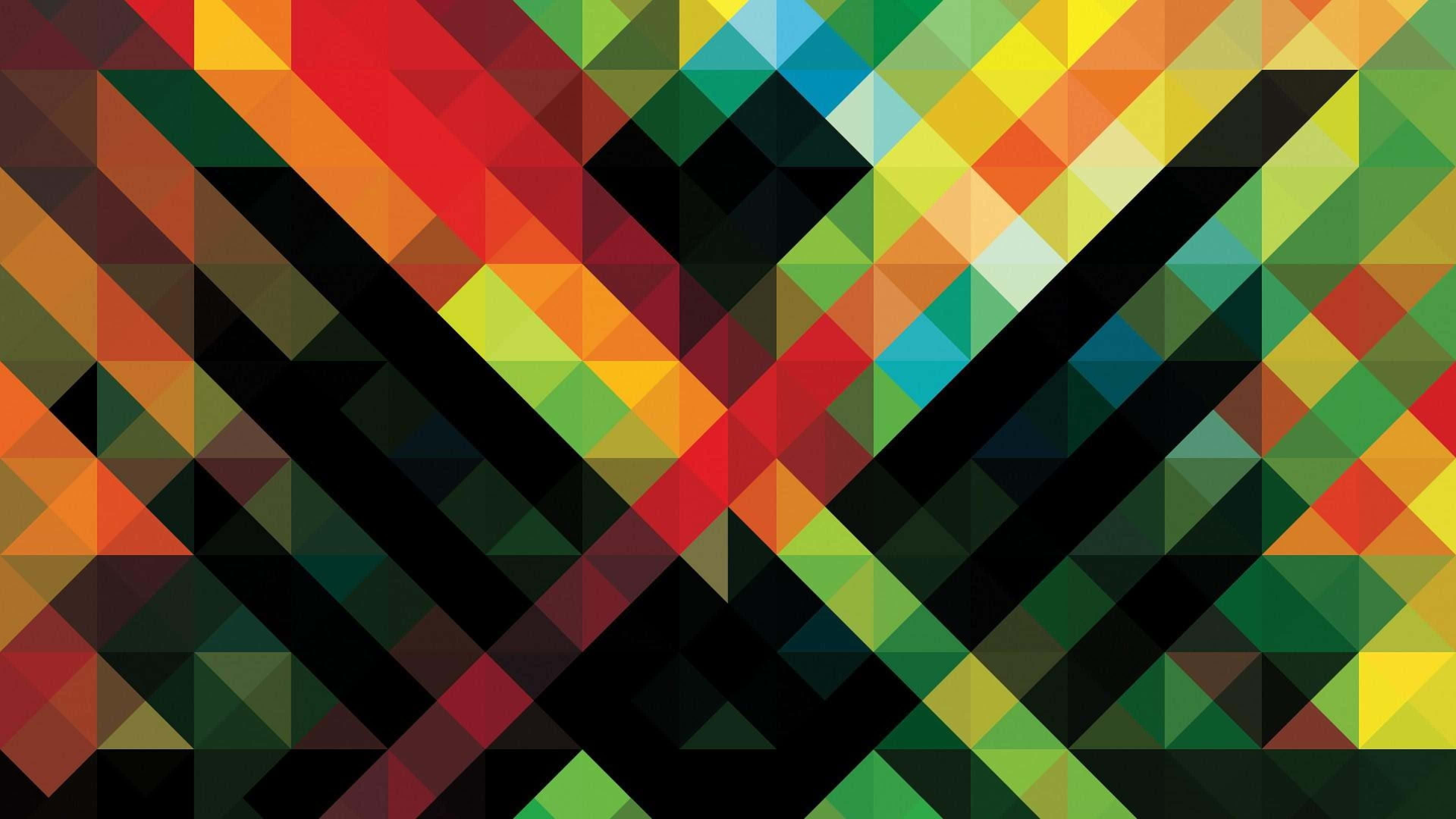 Geometric Desktop 桌布 壁紙 — 充滿活力的幾何三角形以彩虹色調在深黑色背景上形成動態的對角線圖案。