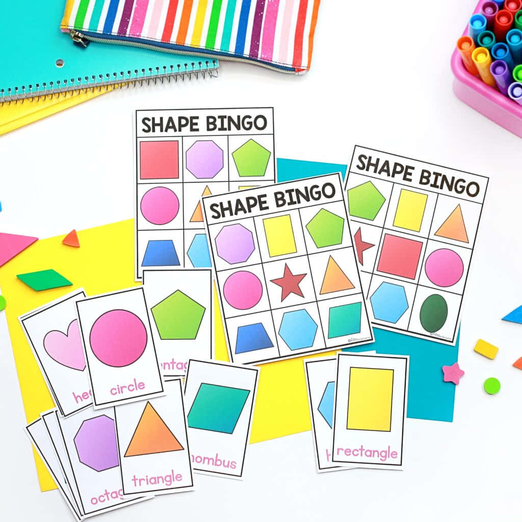 Bingo 桌布 壁紙 — 充滿活力的形狀賓果卡和彩色幾何剪裁散落在明亮的白色表面上，還有學校用品。