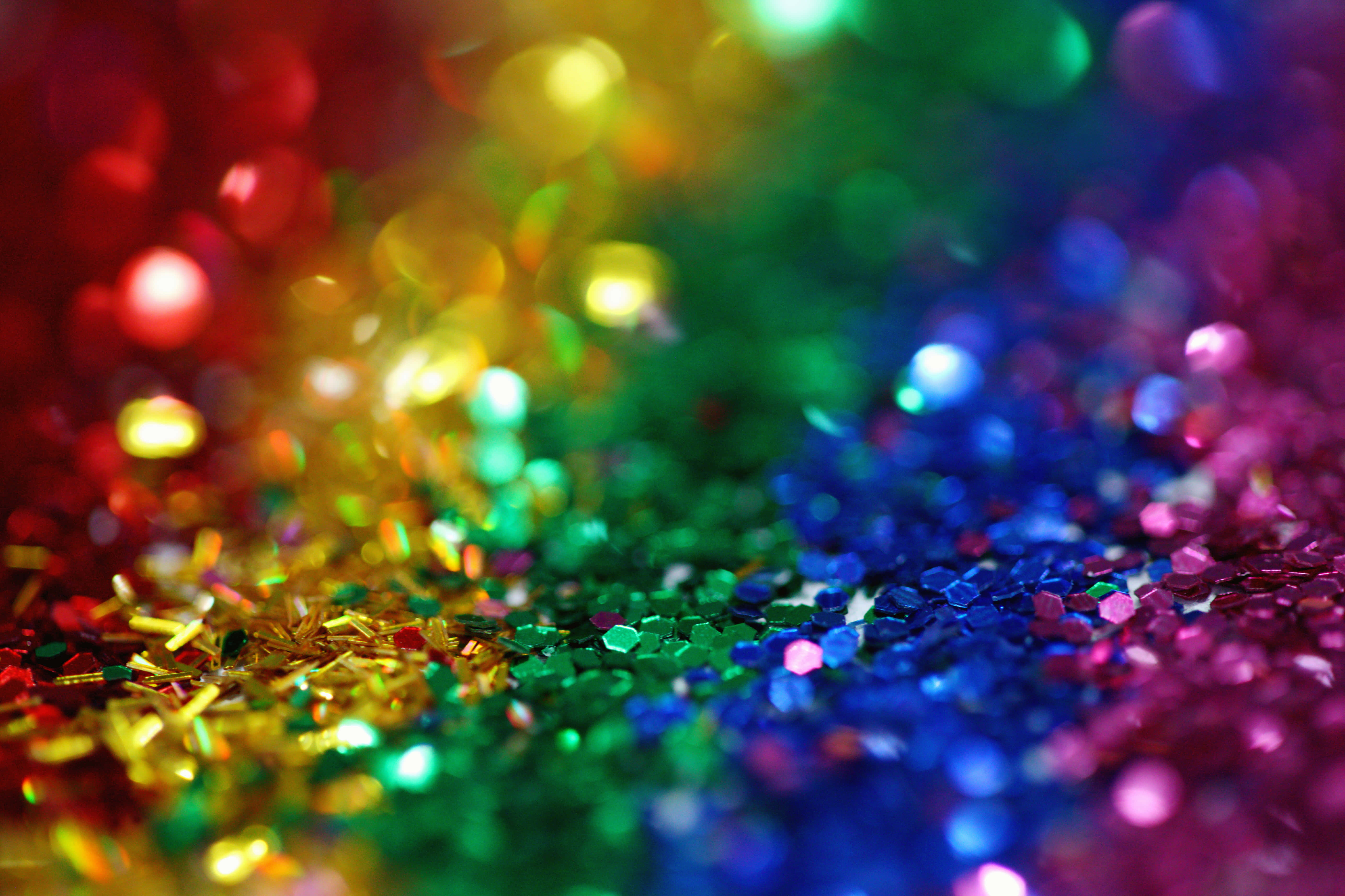 Rainbow Glitter 桌布 壁紙 — 充滿活力的彩虹亮粉特寫，搭配散景燈光，營造出閃爍的節日質感。