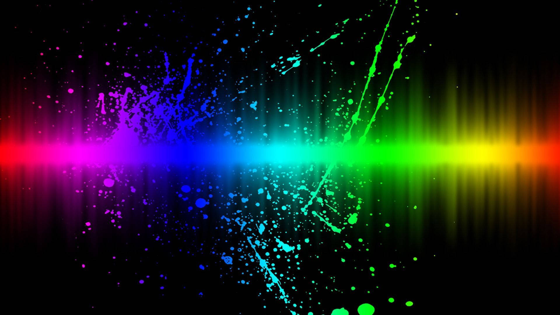 Cool Colorful 桌布 壁紙 — 充滿活力的彩虹光條在黑色畫布上爆發，伴隨著色彩繽紛的油漆飛濺和發光粒子。