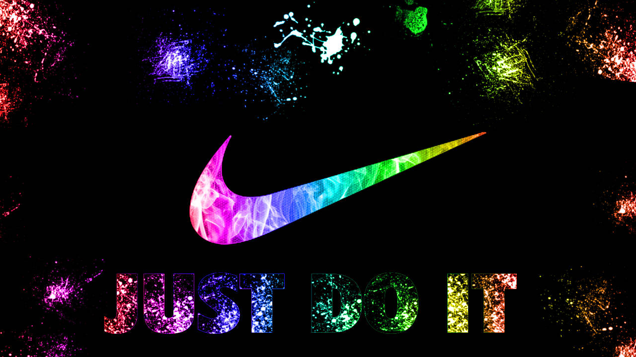 酷炫耐吉 桌布 壁紙 — 充滿活力的彩虹漸變Nike勾號和「JUST DO IT」文字在黑色背景上閃爍，並帶有彩色油漆飛濺。