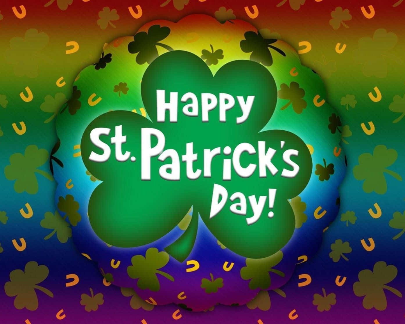 Shamrock 桌布 壁紙 — 充滿活力的彩虹漸變背景，點綴著三葉草和馬蹄鐵，中央是一個綠色的四葉草，上面有「Happy St. Patrick's Day!」文字。