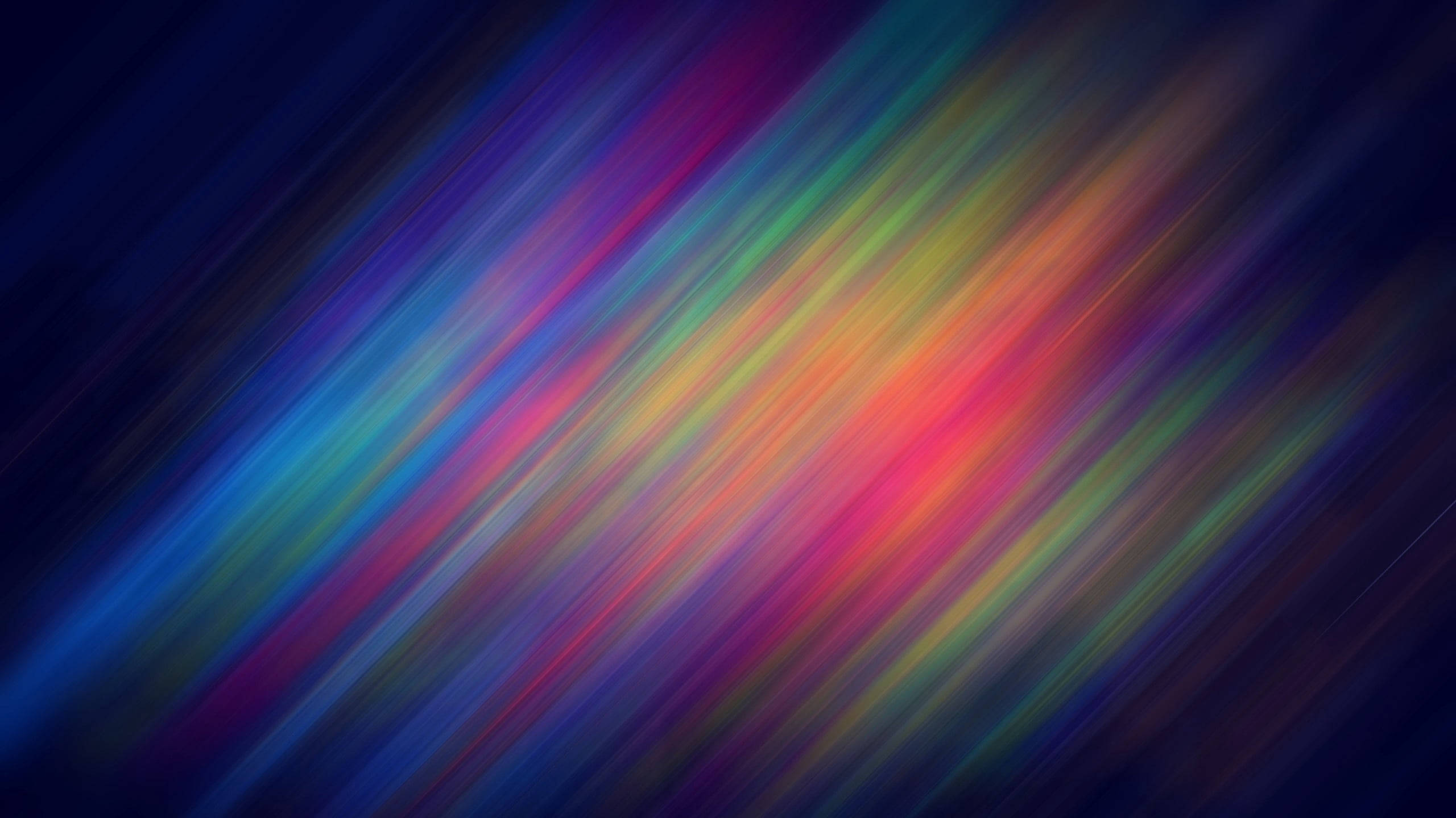 Spectrum 桌布 壁紙 — 充滿活力的彩虹色對角線條在深色背景上模糊，營造出動態的抽象運動效果。