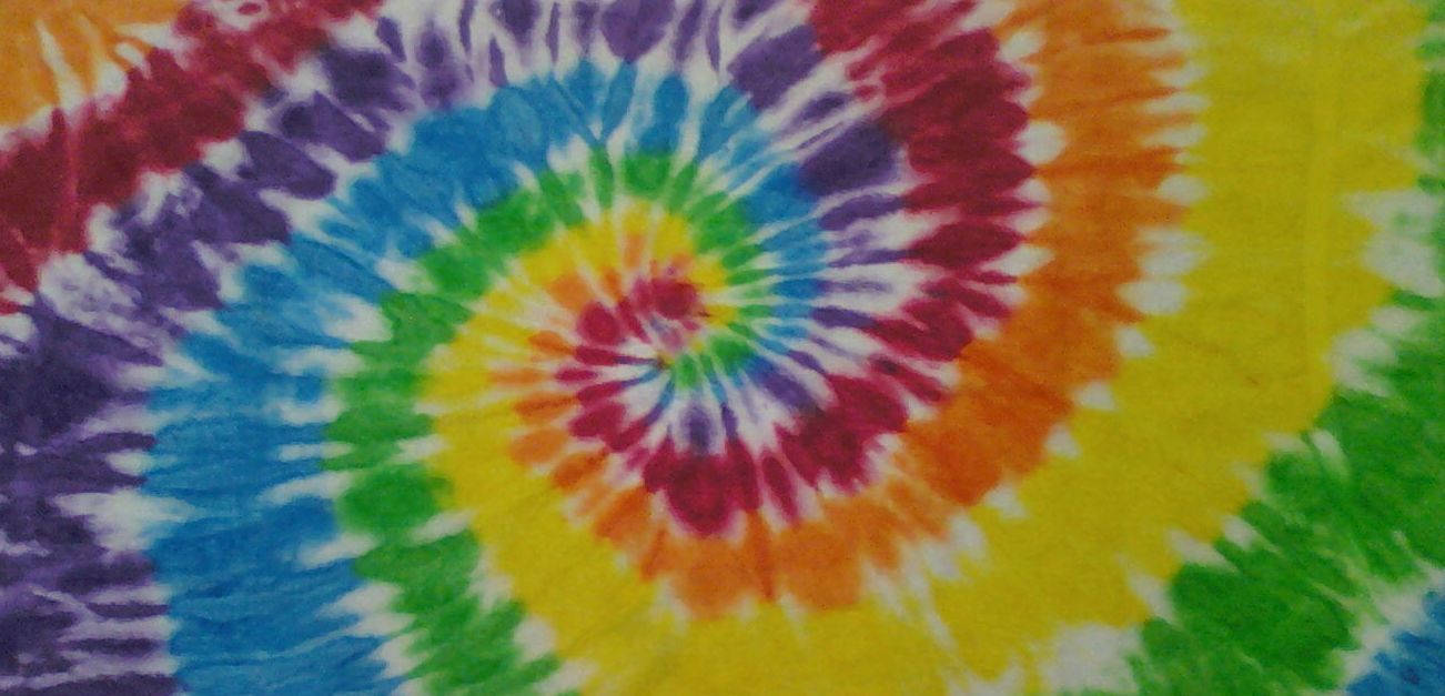 dye 桌布 壁紙 — 充滿活力的彩虹螺旋紮染圖案在布料上以同心圓向外輻射。