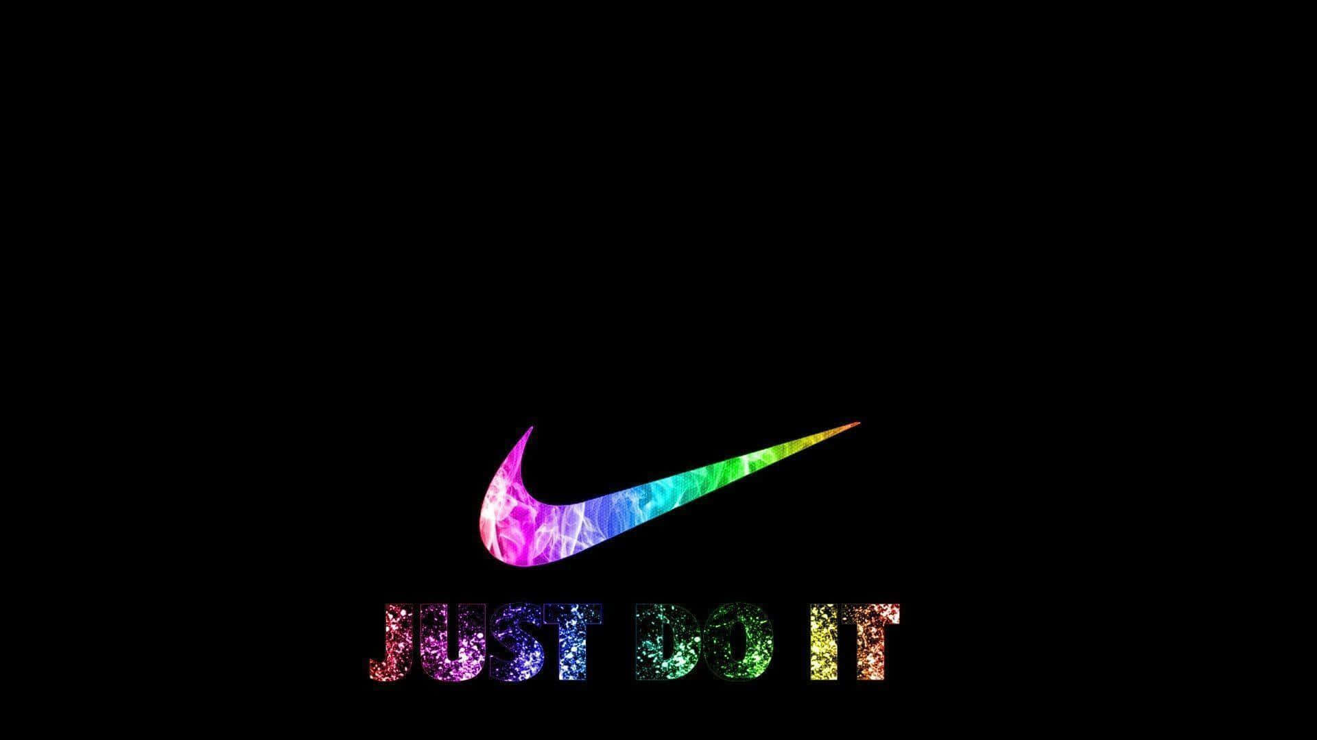 Nike 桌布 壁紙 — 充滿活力的彩虹閃粉Nike勾勾和'JUST DO IT'文字在純黑色背景上發光。