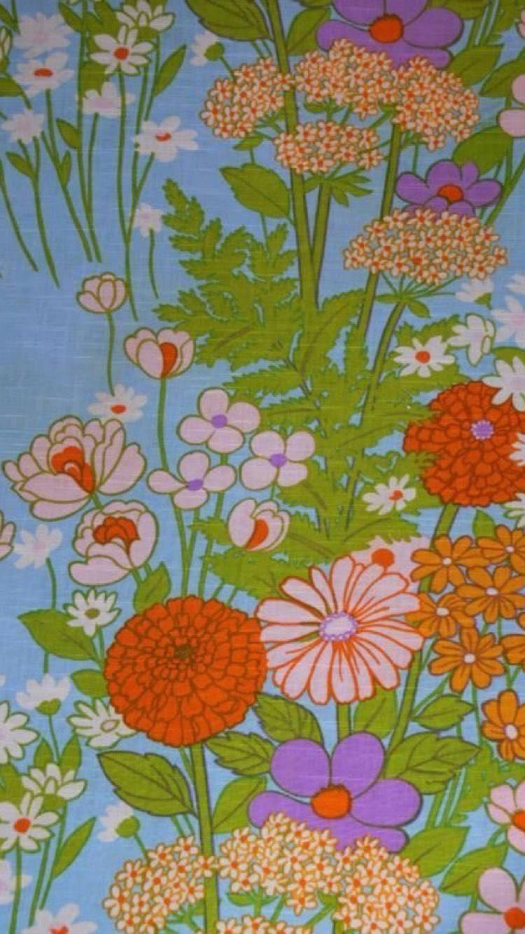 Hippie Aesthetic Laptop 桌布 壁紙 — 充滿活力的復古花卉圖案，帶有橙色、粉紅色、紫色和白色的花朵，在淺藍色布料上。